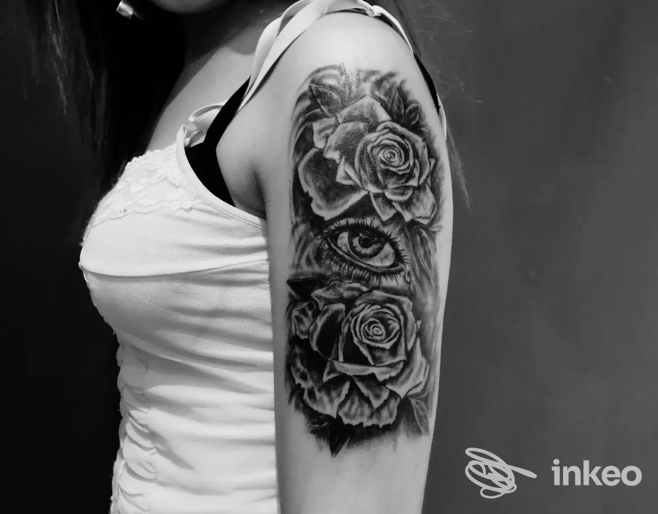 Tatuaggio black & grey con rose e un occhio sul braccio, foto dallo studio Tattoo Giovanett a Trento.