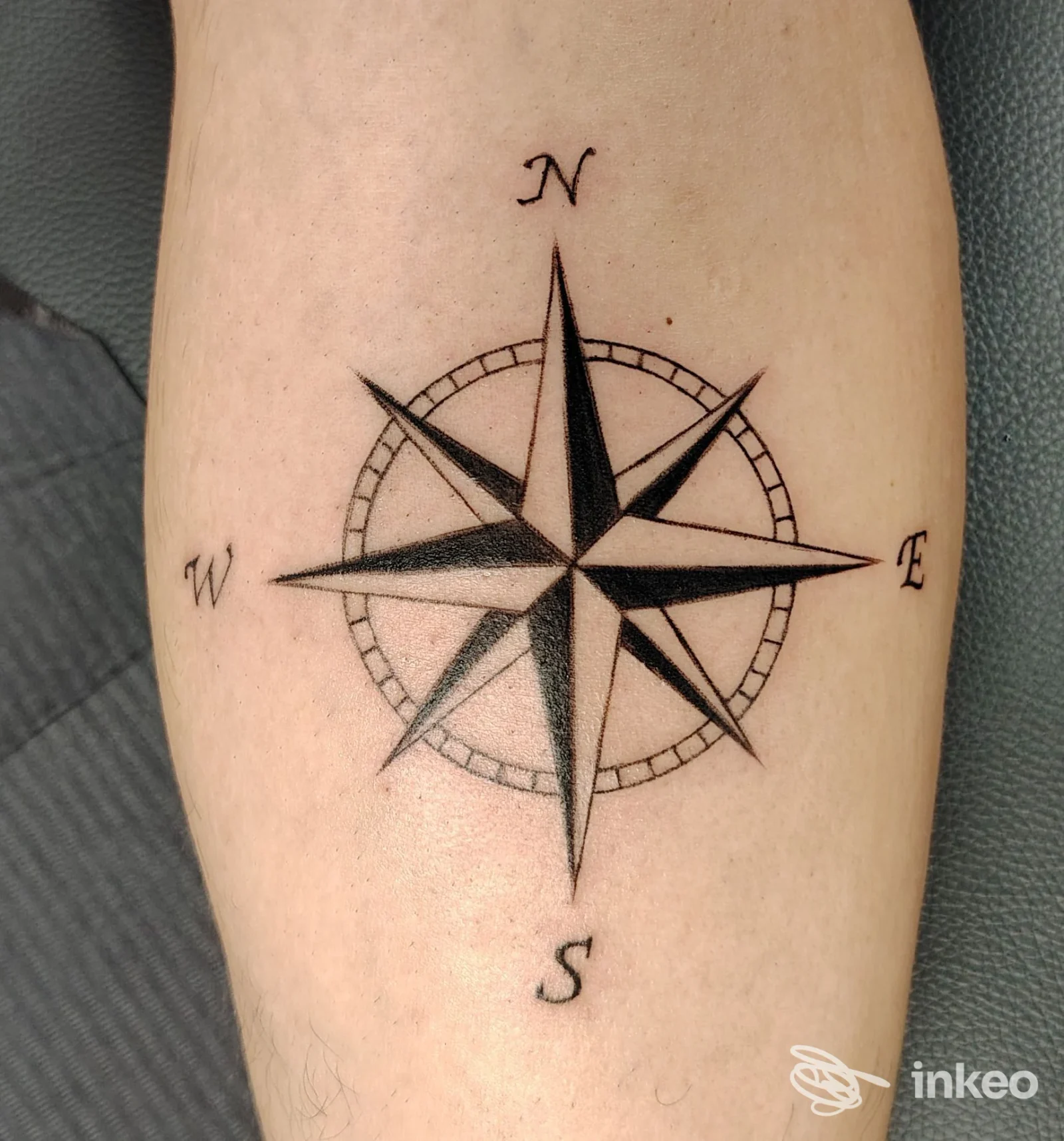 Rosa dei venti tatuata in nero sull'avambraccio, immagine proveniente da Tattoo NO OANS a Barbiano.