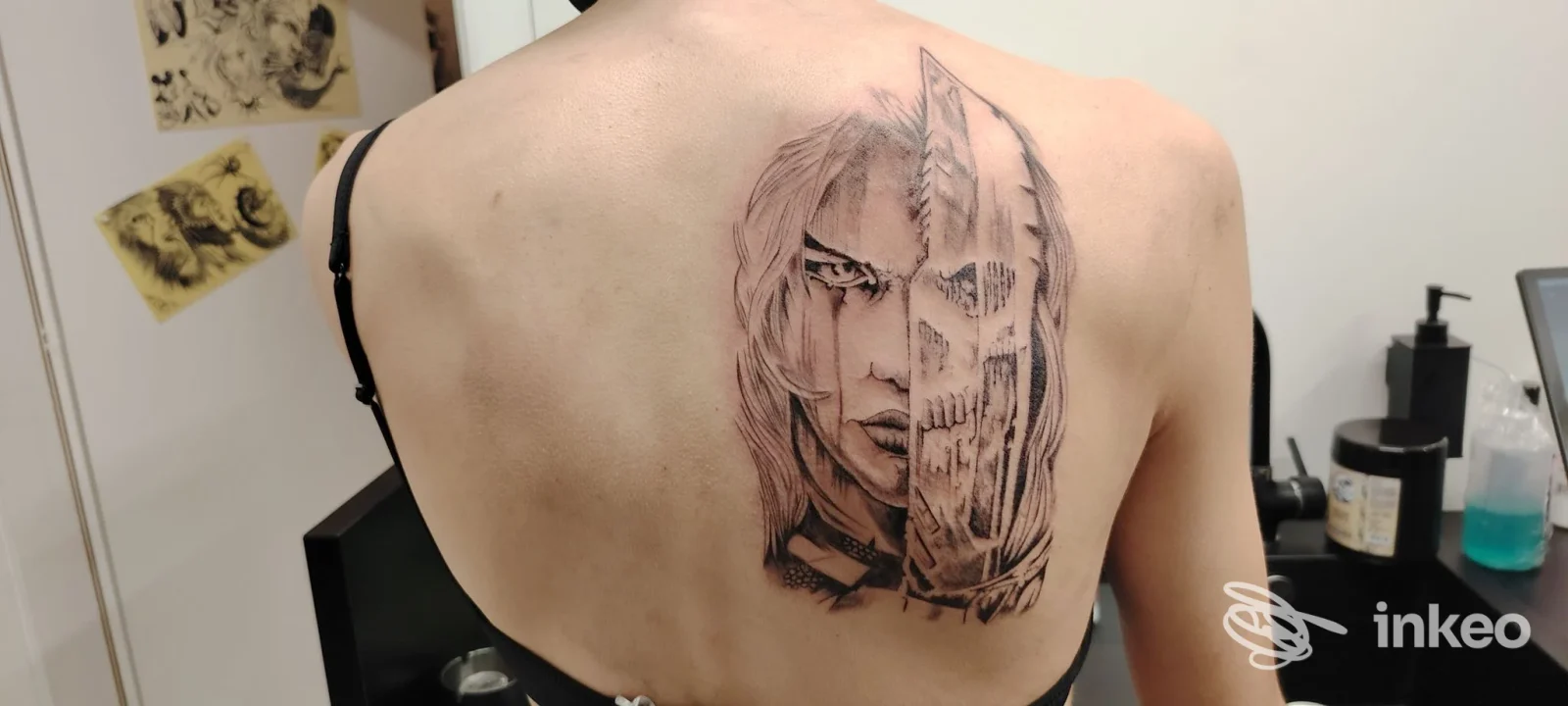 Tatuaggio black and grey sulla parte superiore della schiena con volto metà umano e metà teschio, foto per Tattoo NO OANS a Barbiano.