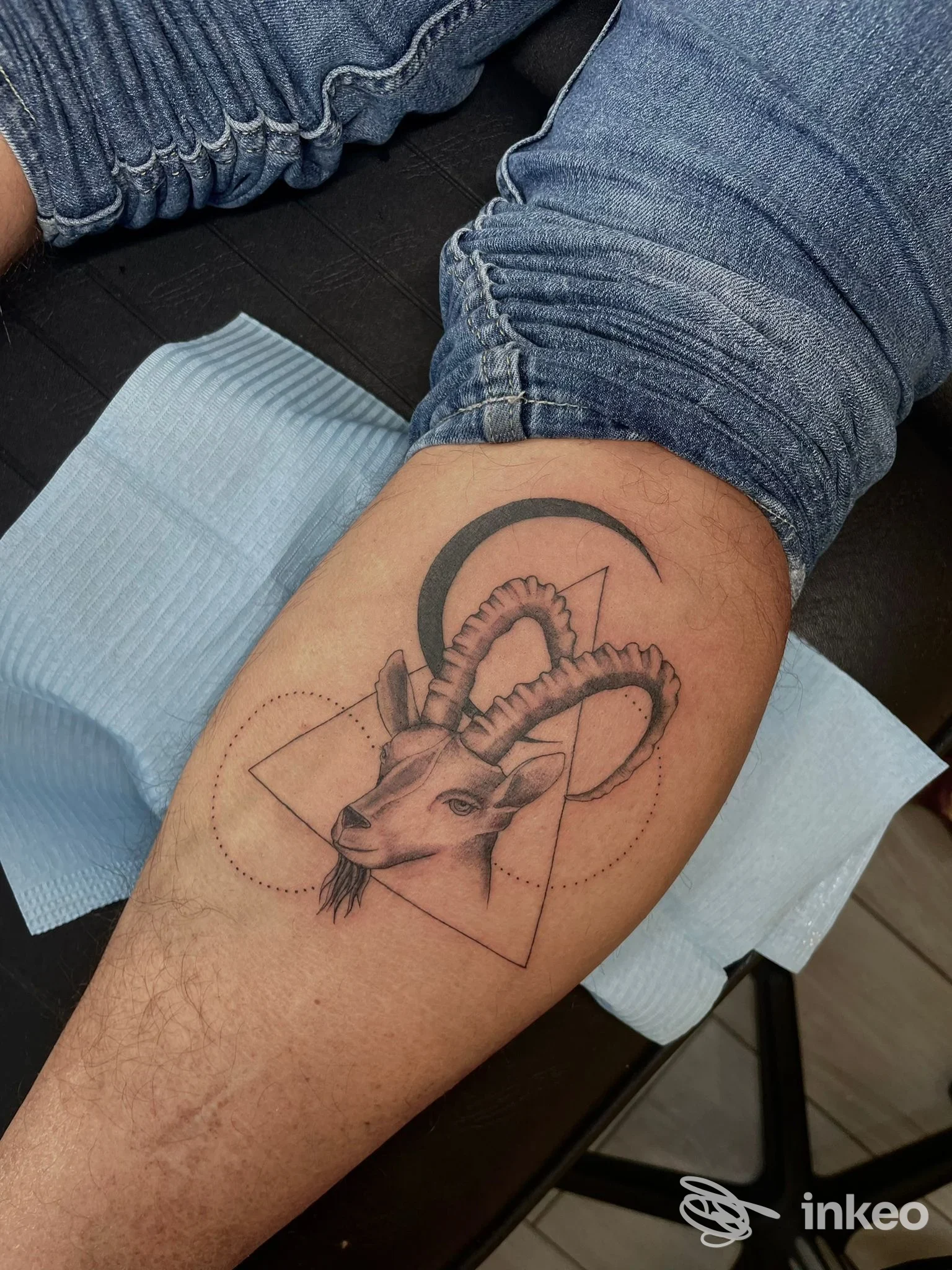 Tatuaggio in nero su polpaccio con testa di stambecco e forme geometriche, eseguito da Tattoosbymarypoppinks a San Paolo.