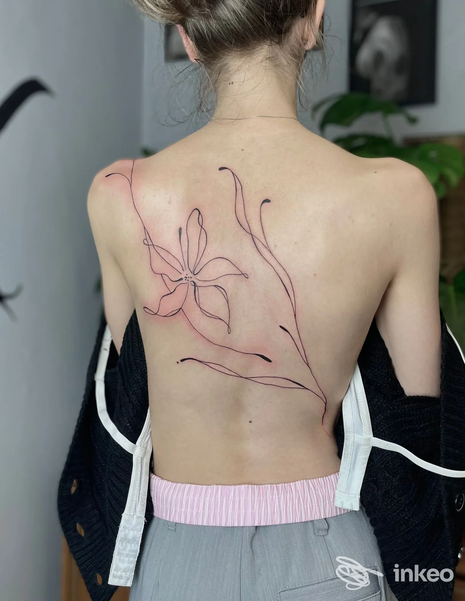 Tatuaggio floreale lineare su schiena femminile, realizzato da Tattoostube 22 a Bressanone.