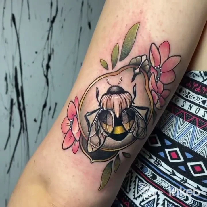 Tatuaggio ape con fiori sull'avambraccio, fotografia per Tattoo Sandra Frena, Chiusa.