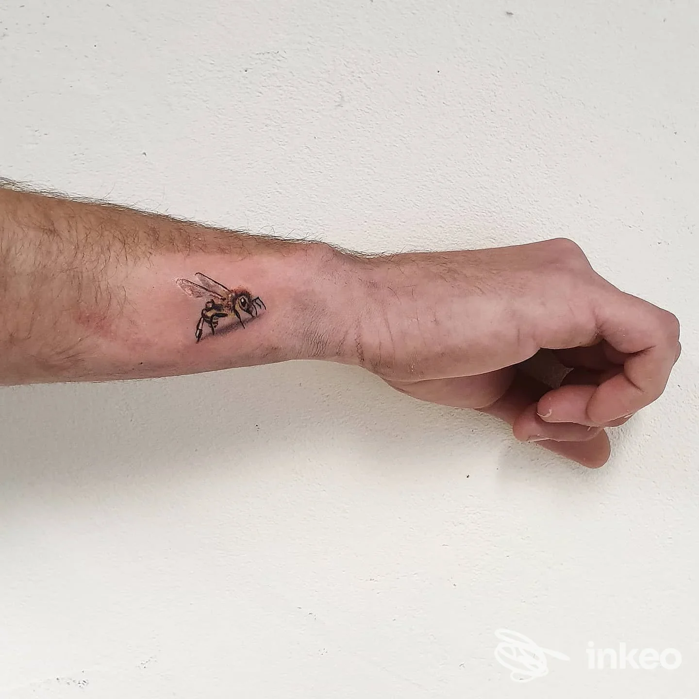 Primo piano di un piccolo tatuaggio a forma di ape sul polso, foto dello studio biz tattoo a Santa Cristina Valgardena.