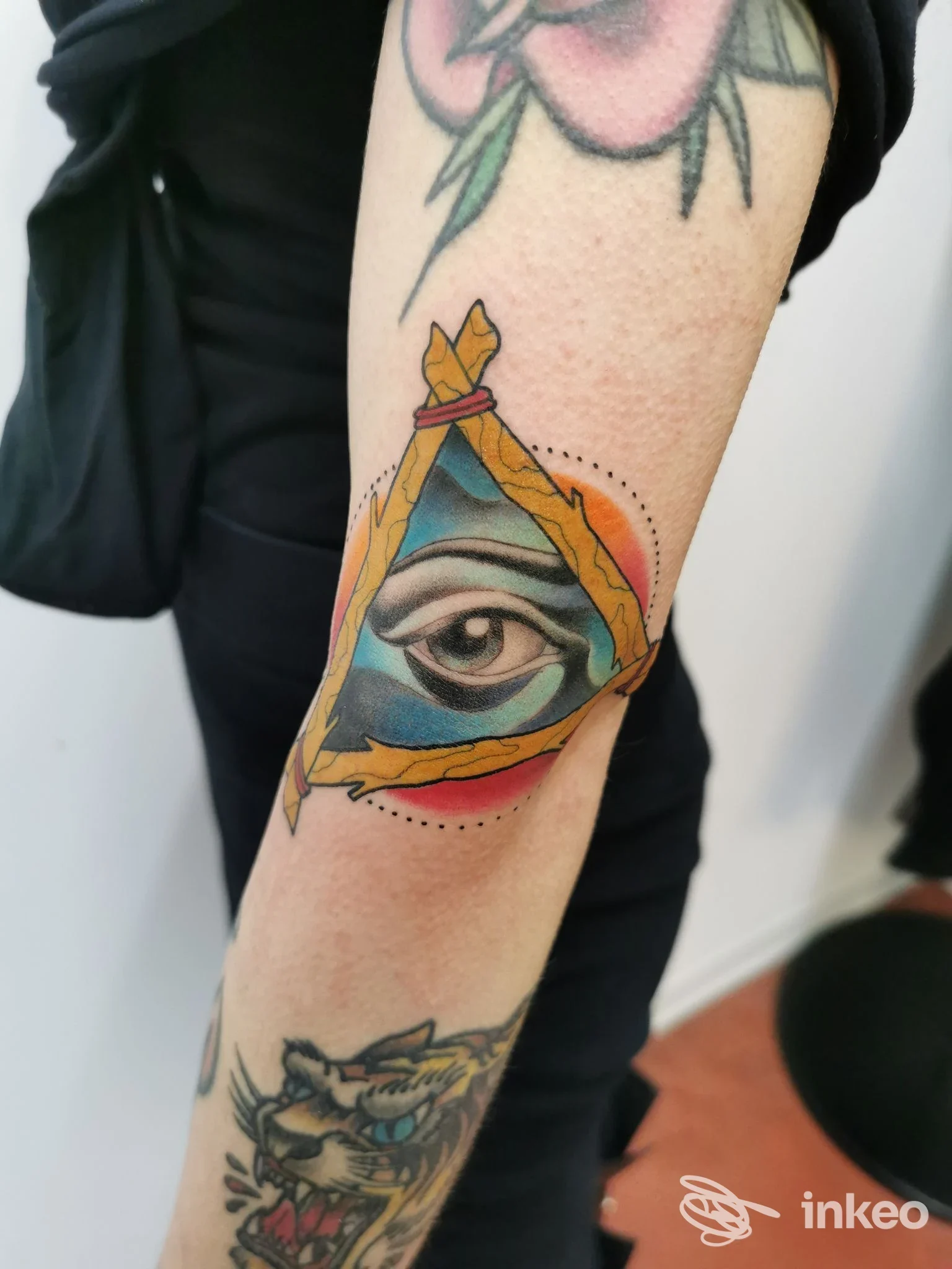 Avambraccio tatuato con un occhio stilizzato dentro un triangolo colorato, foto fornita da ART FACTORY TATTOO a Gubbio.