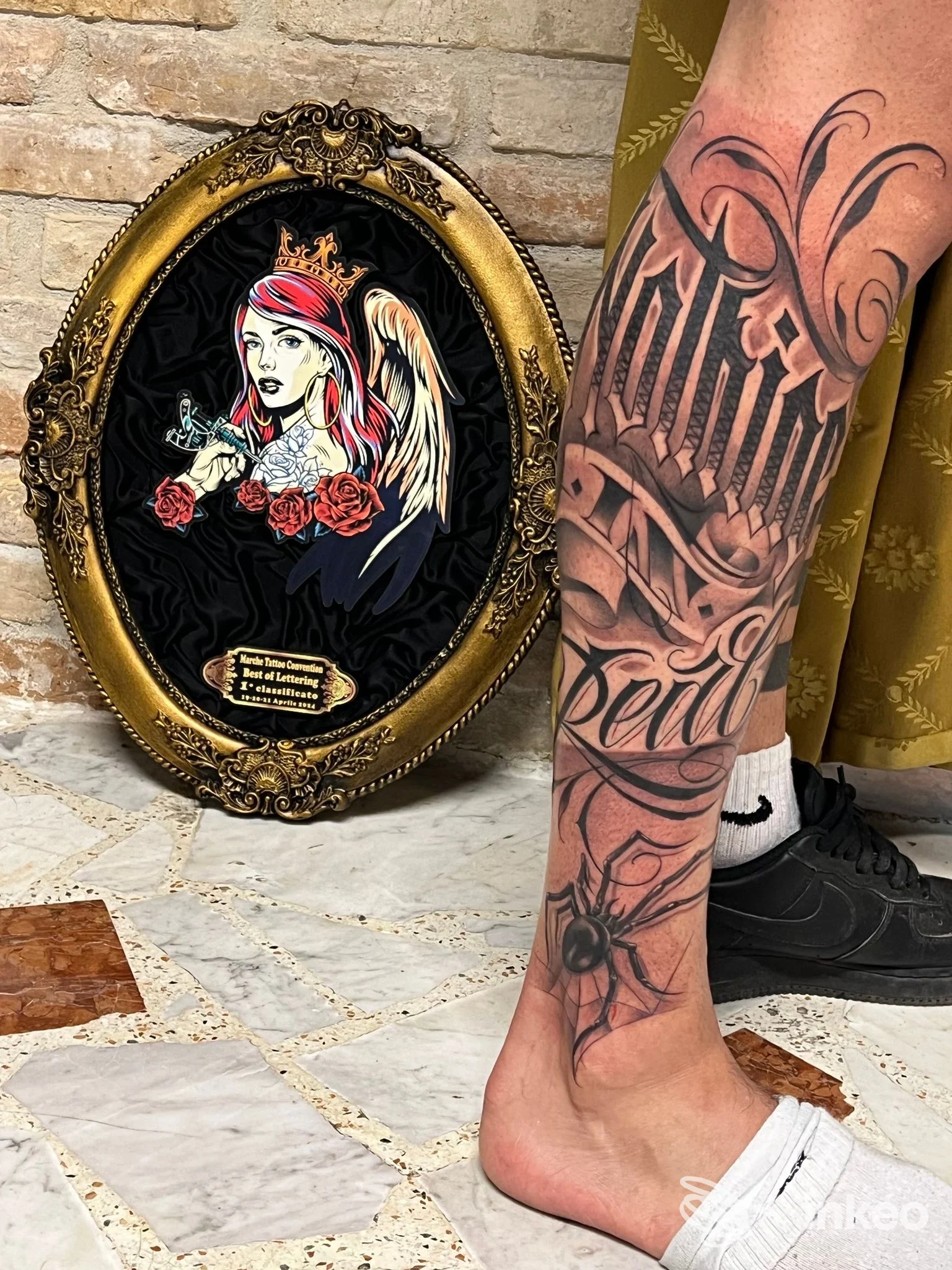 Polpaccio tatuato con lettering ornamentale, foto fornita da Armink tattoo studio, Bevagna.