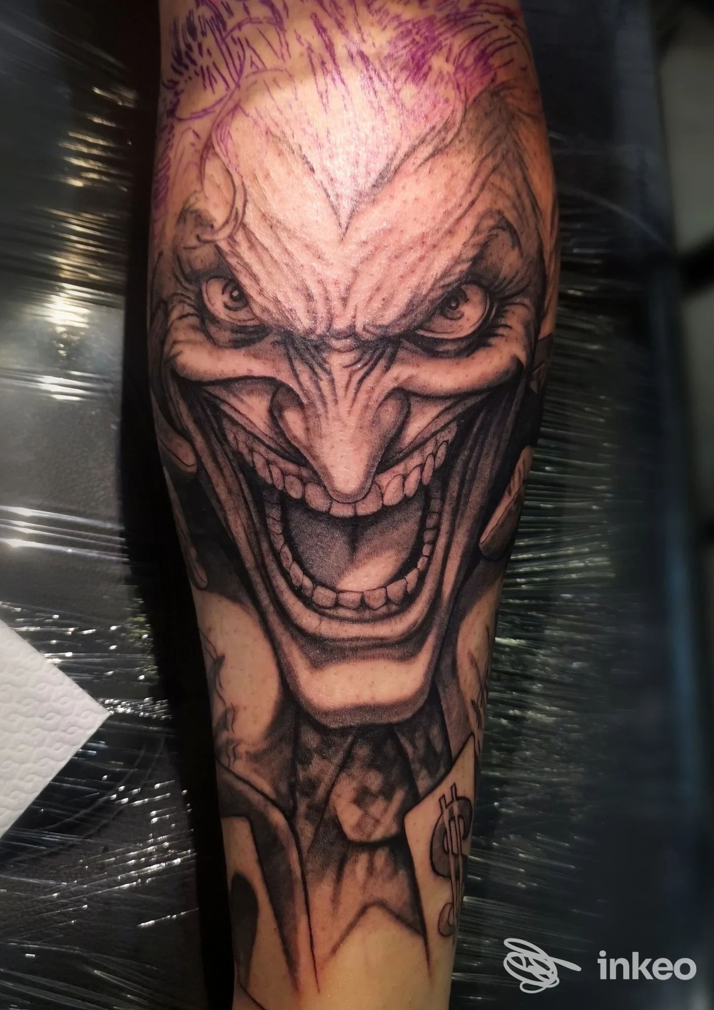 Tatuaggio black-and-grey su avambraccio con volto caricaturale sorridente e minaccioso, Atelier Tattoo Studio di Carmine Cerbone, Corciano.
