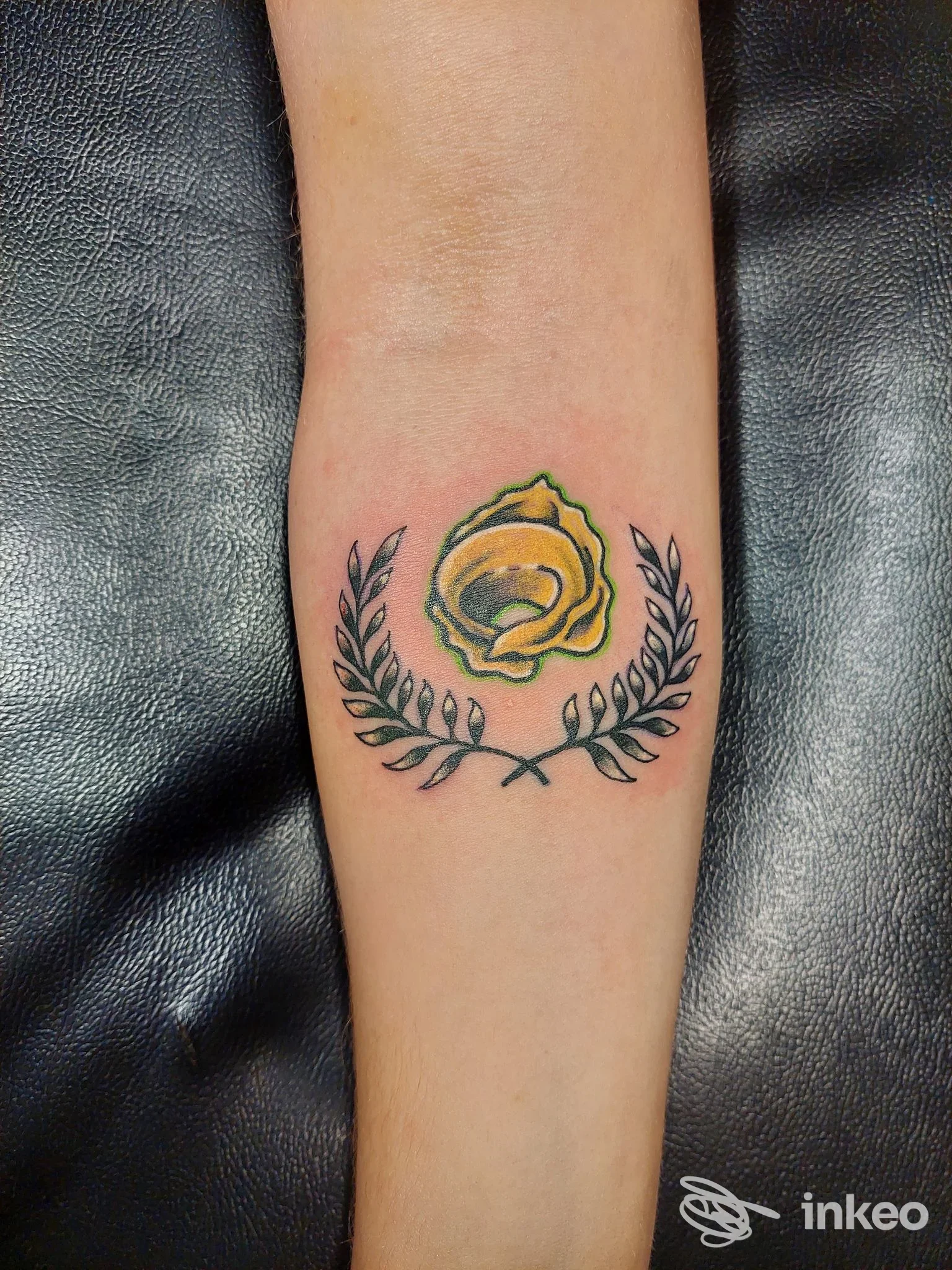 Tatuaggio floreale su avambraccio con rosa gialla e rametti, foto fornita da Beans tattoo, Magione.