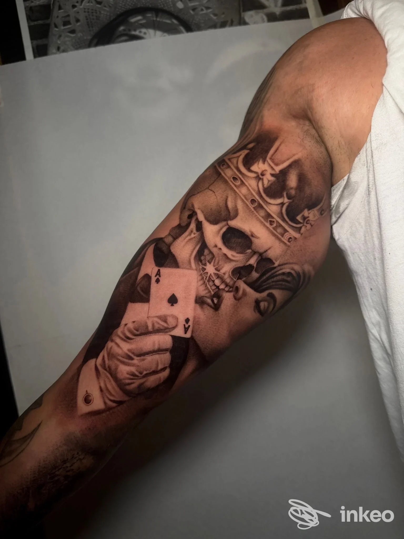 Dettaglio di un tatuaggio black & grey su braccio con teschio coronato e carte, foto fornita da Black Soul Tattoo Studio, Perugia.