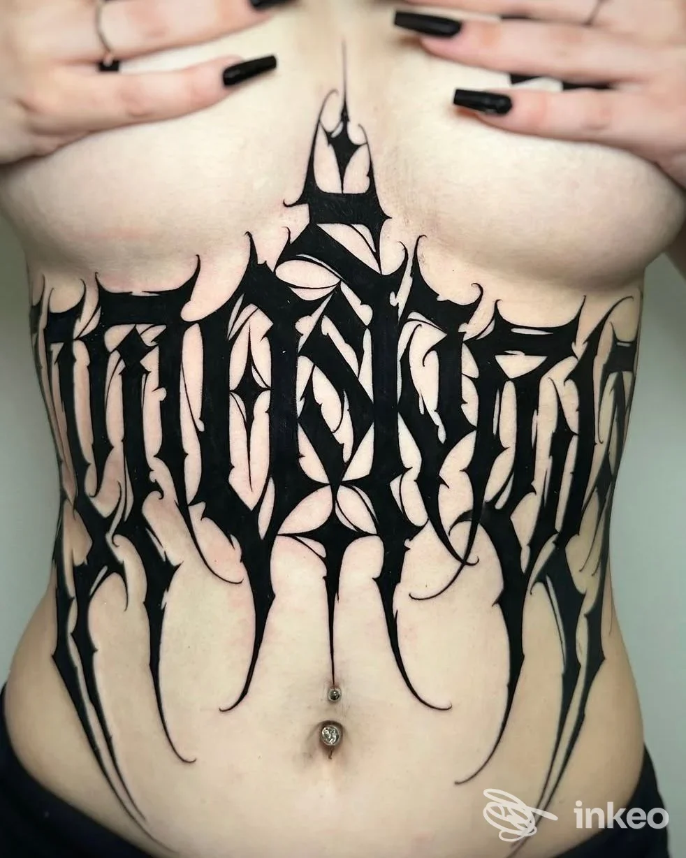 Tattoo molto esteso in stile blackletter su torace e addome, realizzato su pelle: la persona tiene le mani ai lati.