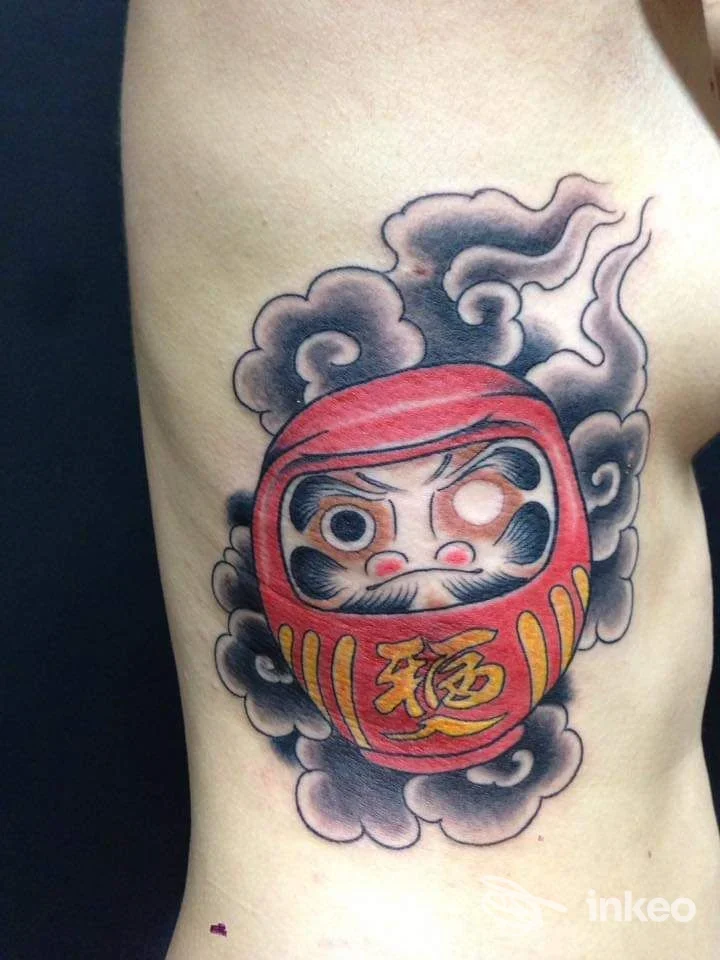 Tatuaggio Daruma rosso con ombreggiature fumogene sul costato, Bonnie Tattoo Studio, Corciano.