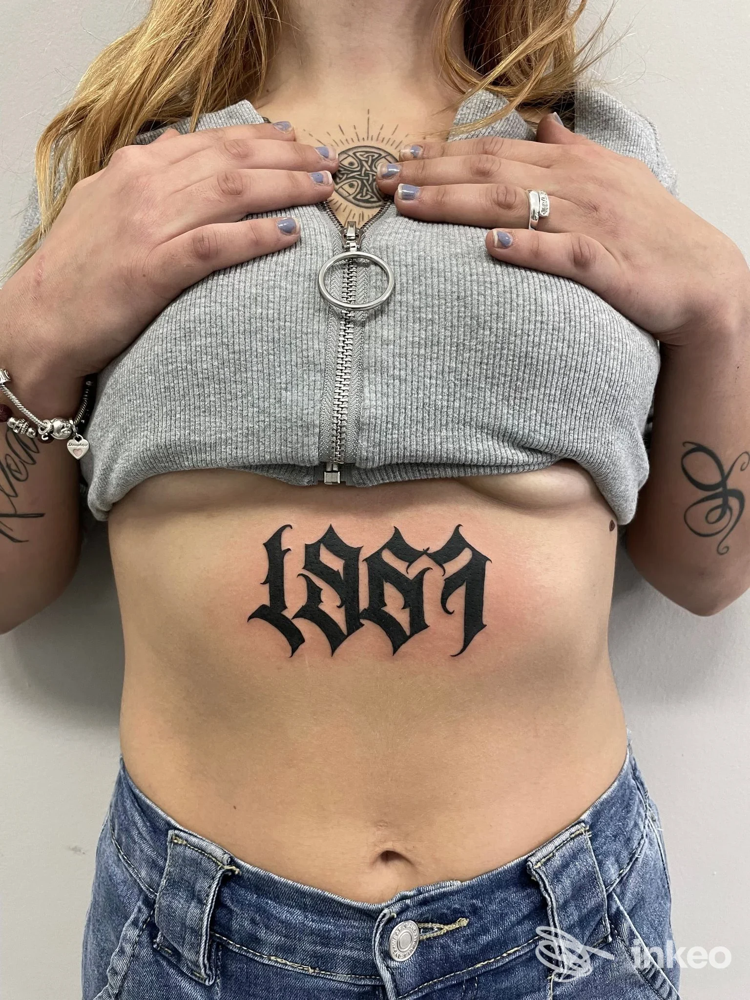 Tatuaggio in nero in stile lettering gotico sull'addome superiore, foto fornita da How I Met Your Ink tattoo studio, Gubbio.