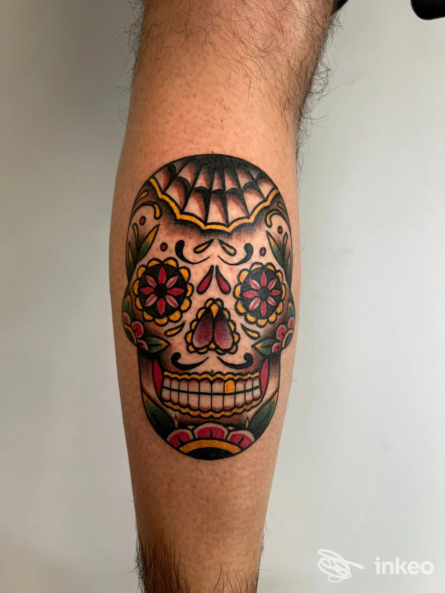 Tatuaggio sugar skull a colori sul polpaccio, foto di Ink'em All Tattoo a Terni che mostra dettagli e saturazione dei pigmenti.
