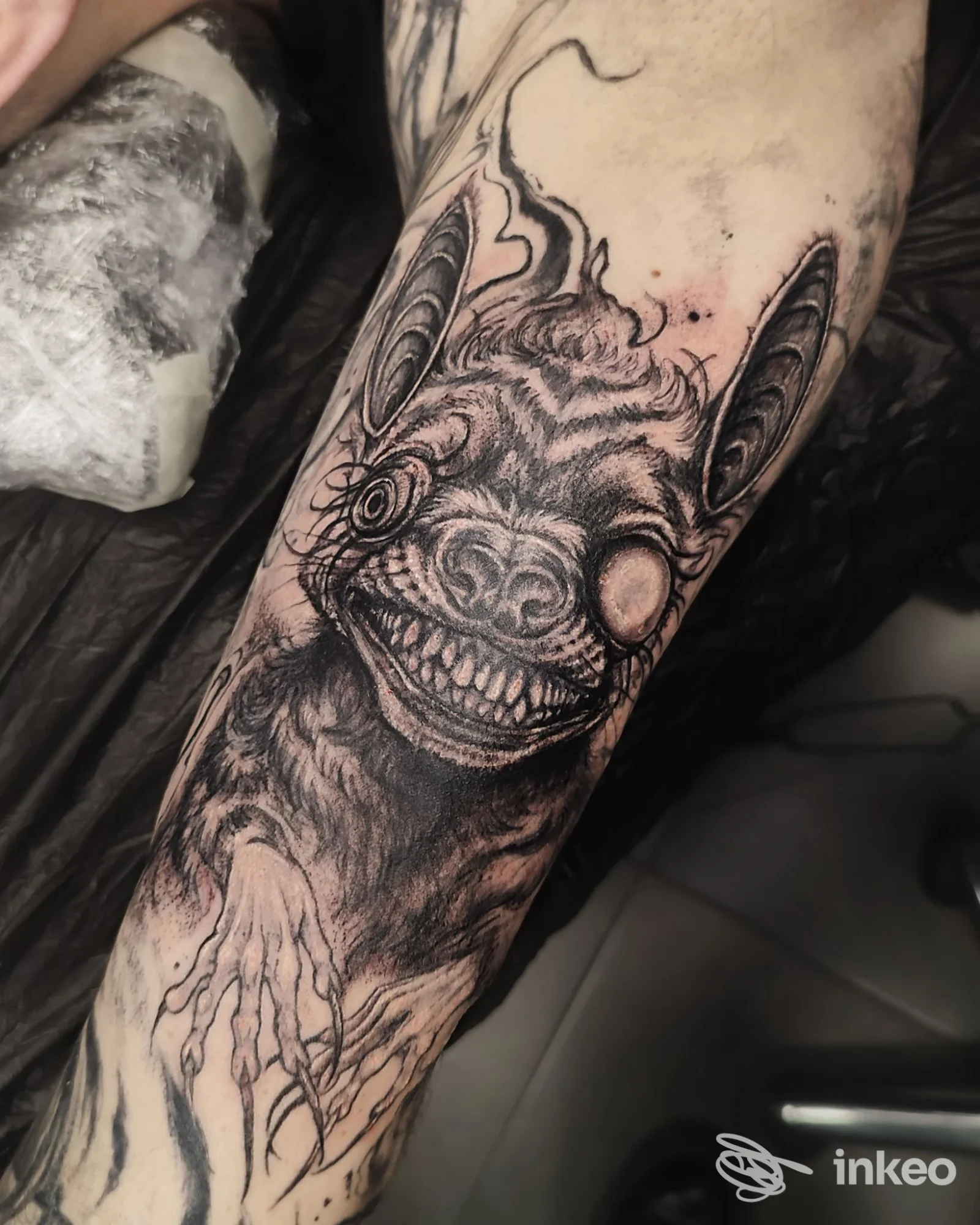 Tatuaggio in bianco e nero sull'avambraccio raffigurante una creatura mostruosa; Doomnesia Tattoo Studio, Terni.