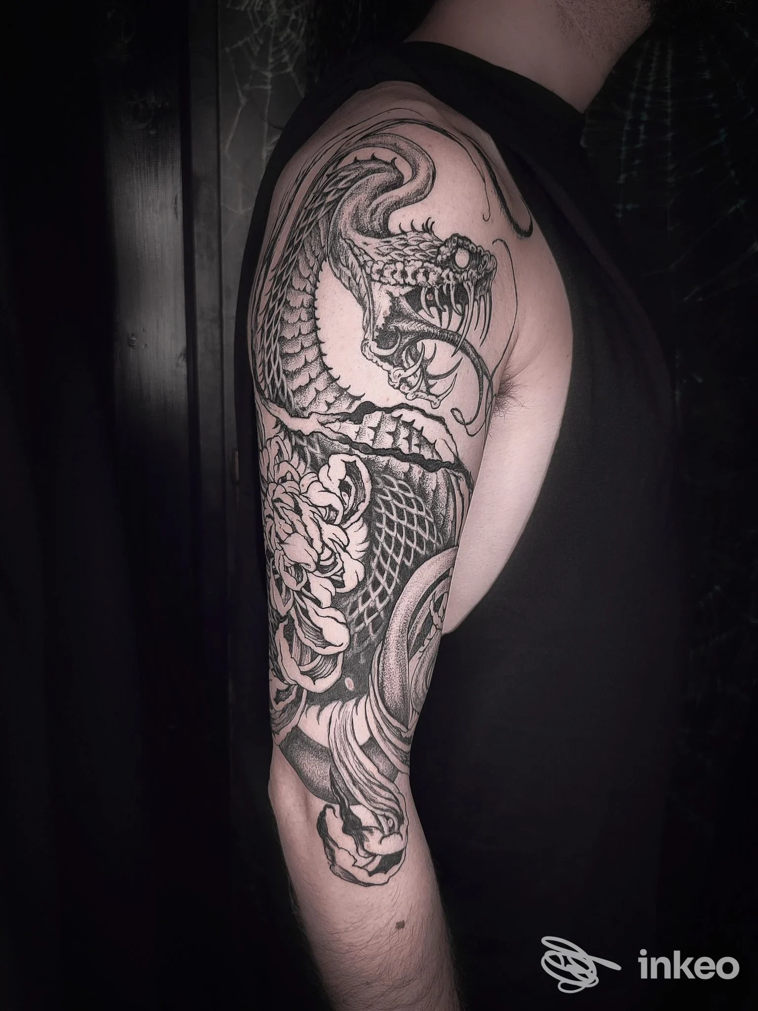 Ampio tatuaggio a tema serpente su braccio e spalla, fotografato in profilo. Doomnesia Tattoo Studio, Terni.
