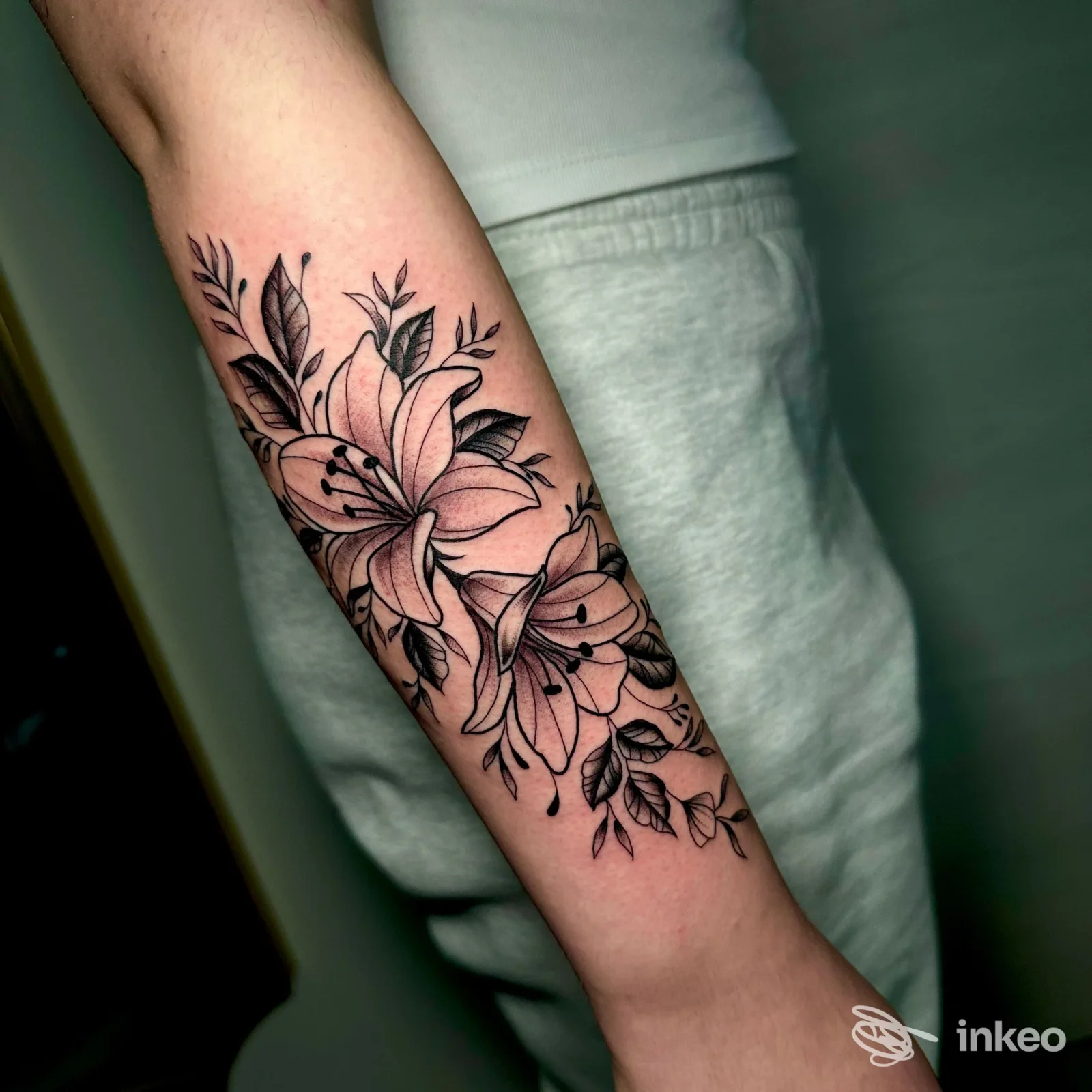 Tatuaggio floreale in bianco e nero sull'avambraccio, eseguito da Fraffry Tattoo e Piercing ad Amelia, dettagli con linee nette.