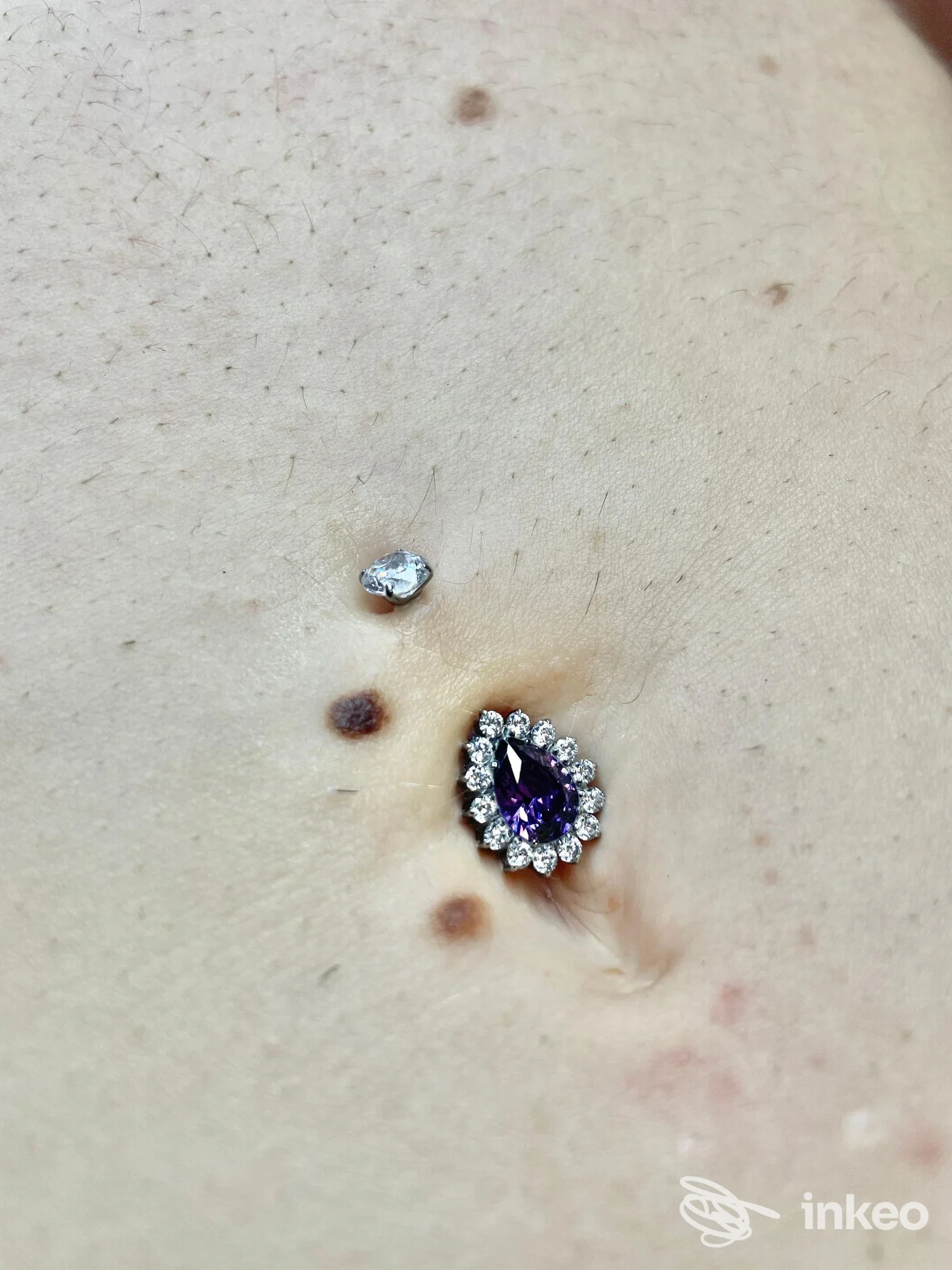 Piercing ombelicale con gioiello viola circondato da strass, MOSCABIANCA tattoostudio, Bastia Umbra.