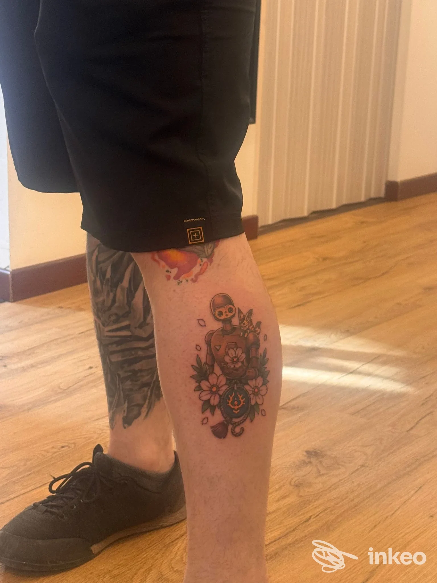 Dettaglio del tatuaggio a colori sul polpaccio di una persona, Metamorfosi Tattoo Studio, Perugia.