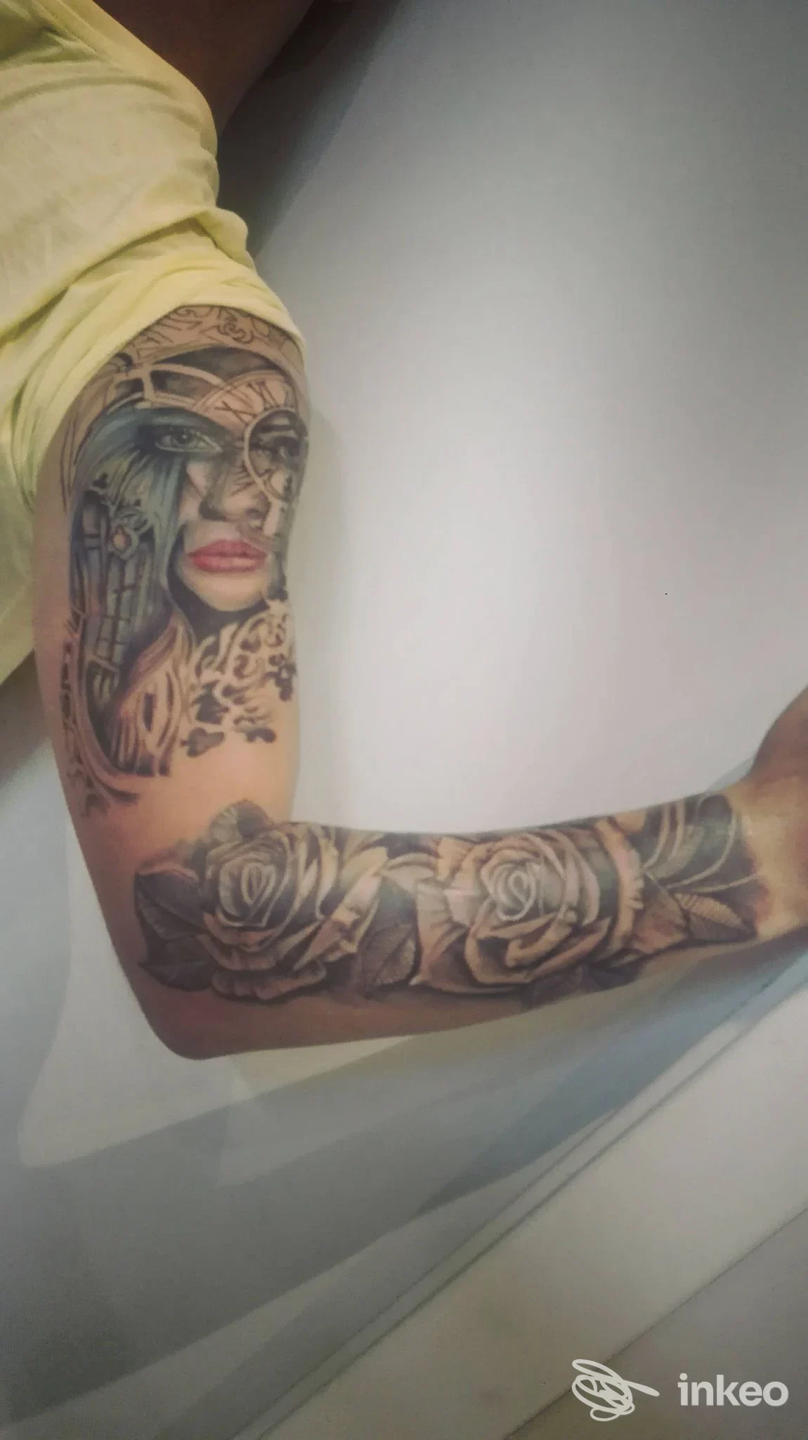 Mano e braccio tatuati con un ritratto femminile realistico e due rose in bianco e nero, foto inviata da Miky Tattoo Saloon a Spoleto.