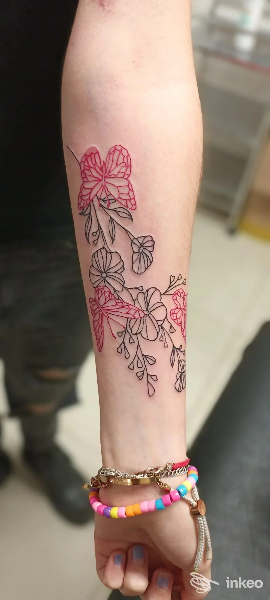 Avambraccio con tatuaggio floreale lineare in nero e riempiture rosa, foto di Miky Tattoo Saloon, Spoleto.