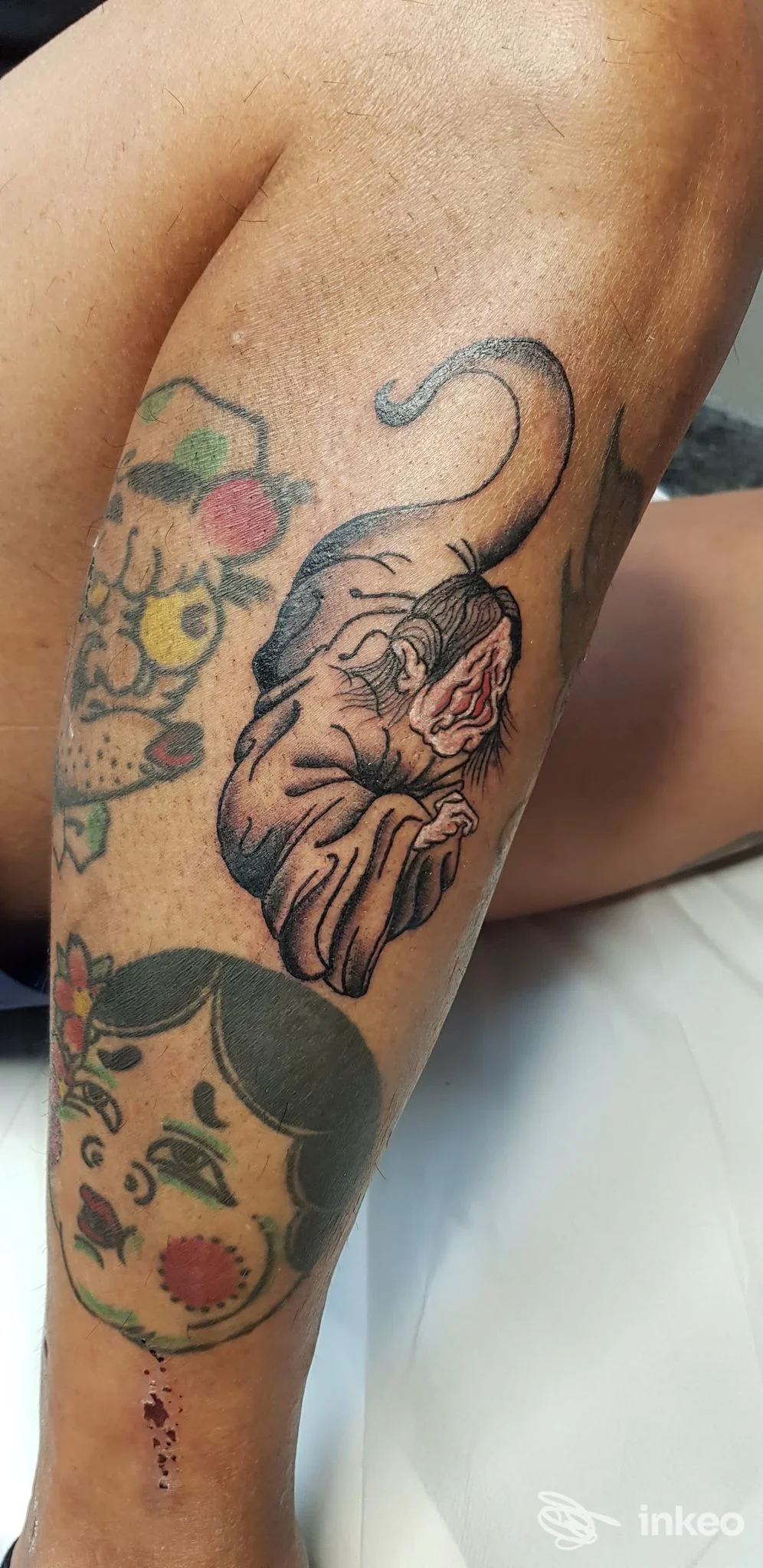 Avambraccio tatuato con più soggetti, inclusa una figura scura centrale; foto fornita da Ocean ink tattoo studio, Trevi.