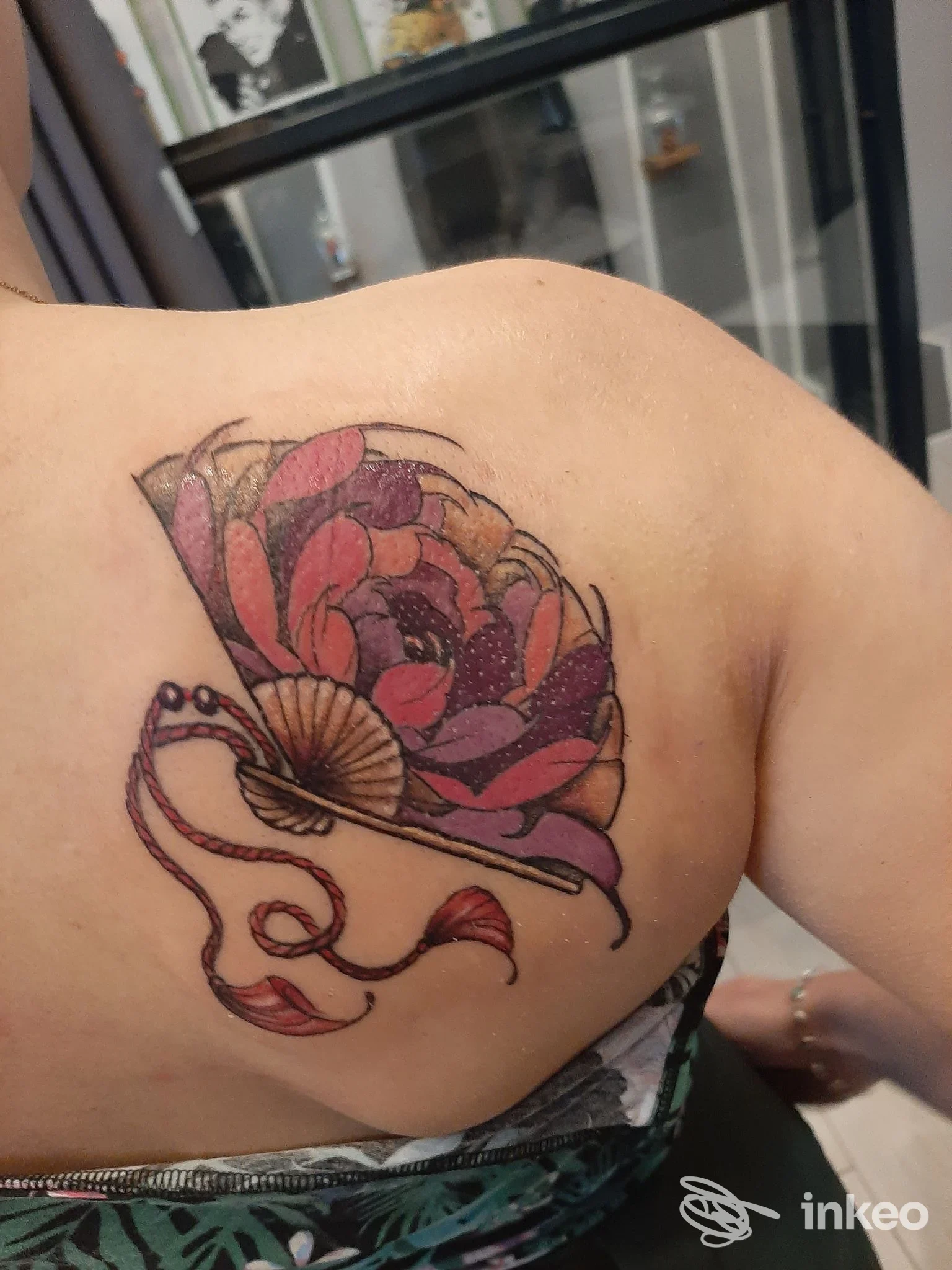 Tatuaggio floreale colorato sul lato superiore della schiena/spalla, foto fornita da Martius Tattoo Studio, Cerbara.