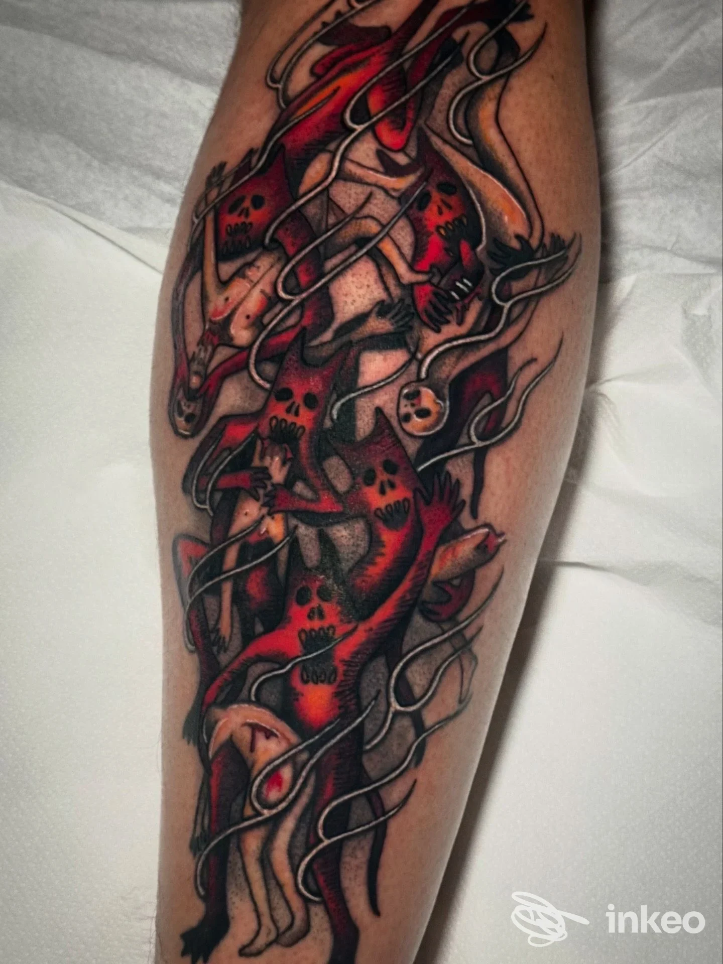 Tatuaggio colorato su polpaccio con figure scheletriche e volti stilizzati, fotografia di Martius Tattoo Studio, Cerbara.