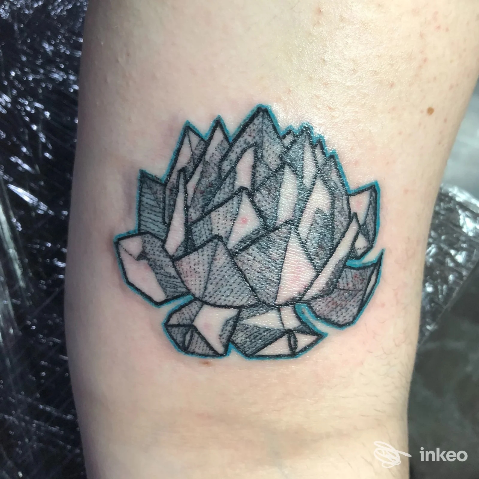 Tatuaggio geometrico a forma di fiore/lotus sull'avambraccio, eseguito da P.Ink Noir Tattoo Studio a Foligno.