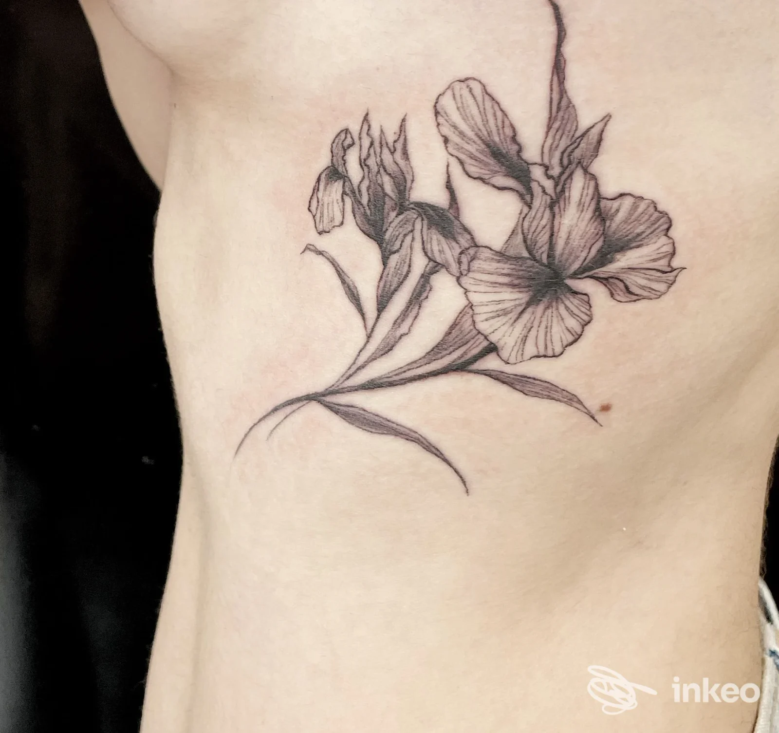 Tatuaggio floreale linework sul fianco sinistro su pelle reale, realizzato da Saretta Project Ink Tattoo a Terni.
