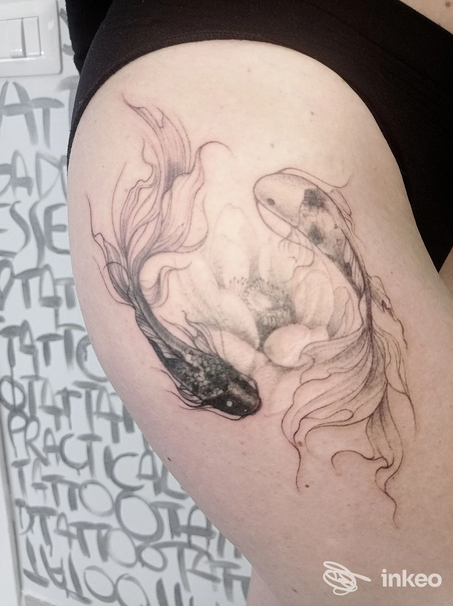 Tatuaggio di due koi stilizzate sul lato superiore della coscia, realizzato da Rebel Therapy Tattoo Studio a Gualdo Tadino.