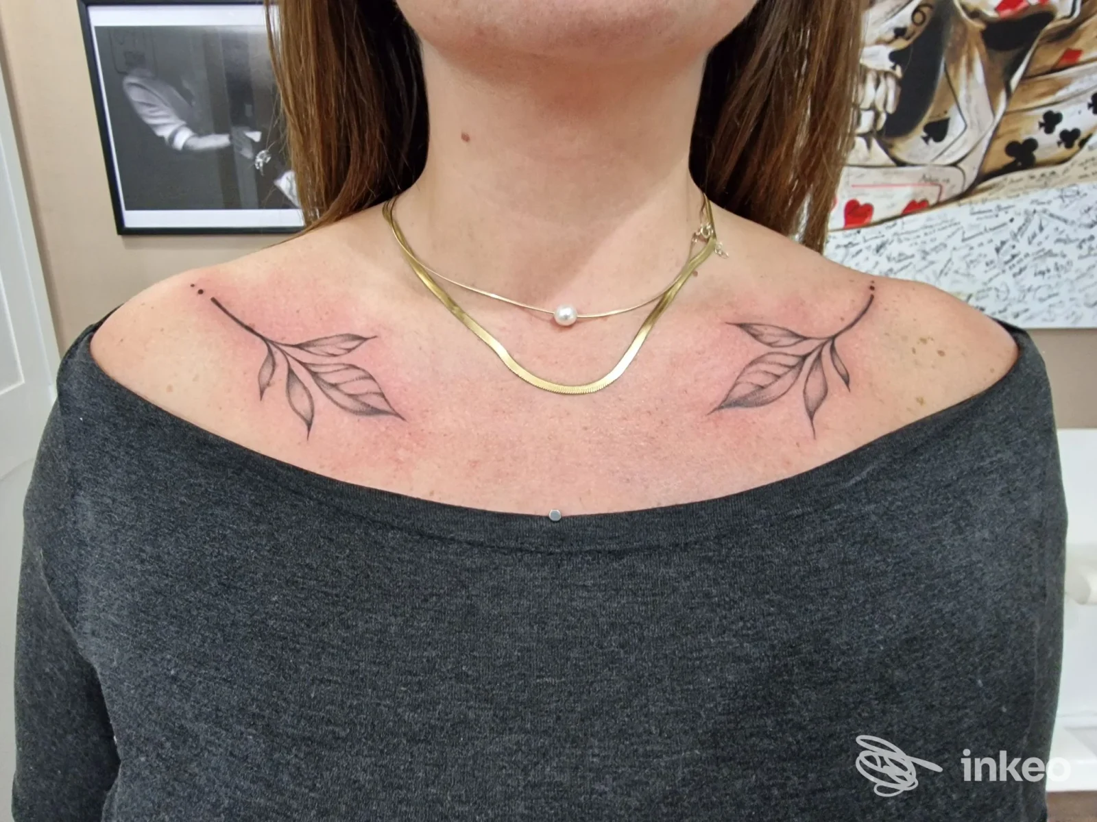 Due piccoli tatuaggi a forma di ramo sulle clavicole di una cliente, collo e décolleté visibili, Sara Tattoo, Brufa.