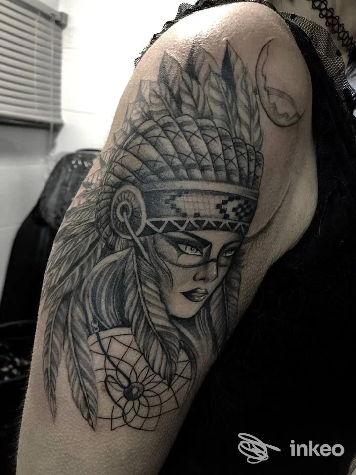 Tatuaggio black & grey su braccio: volto di donna con copricapo di piume e acchiappasogni — Screaming Tattoo, Terni.