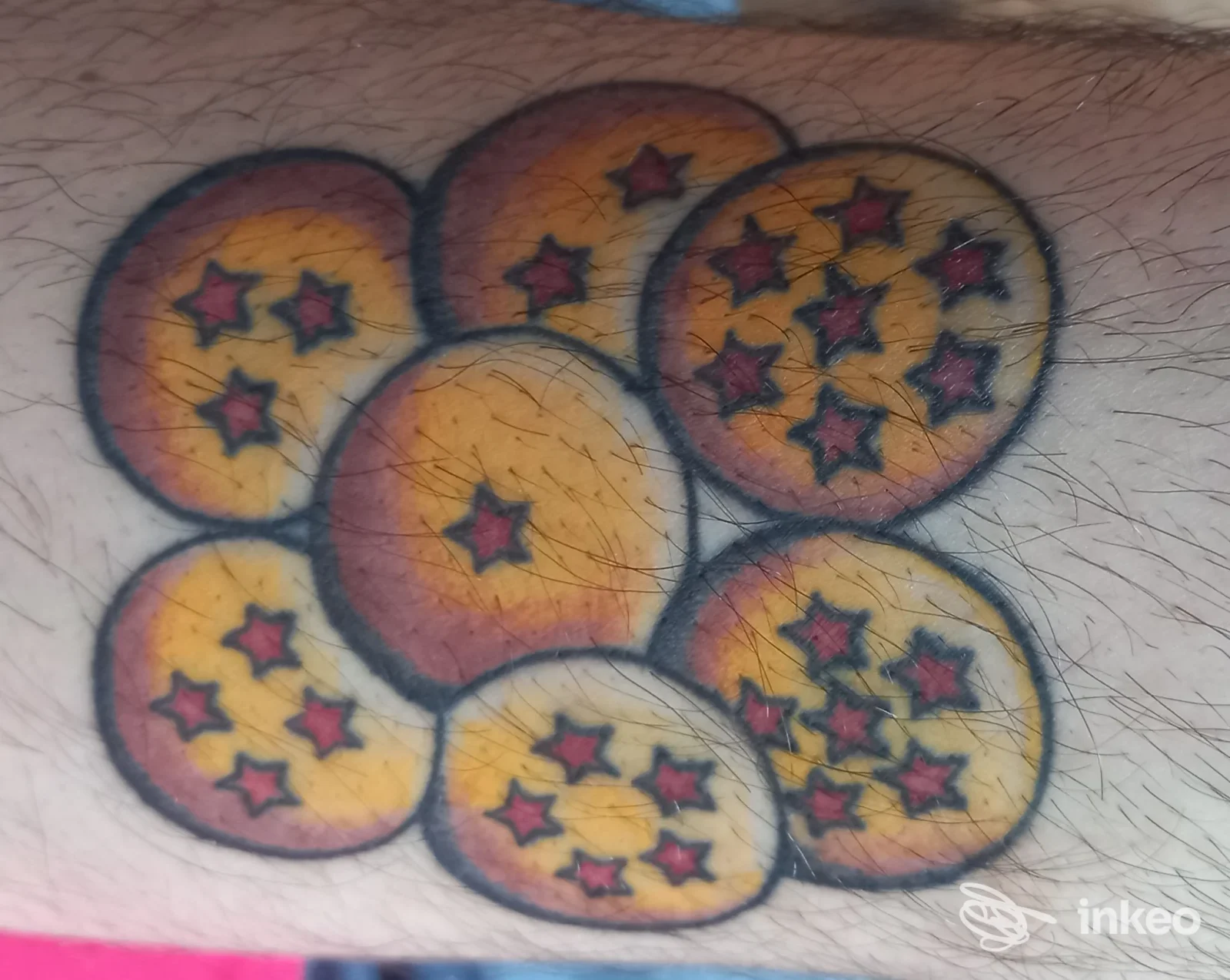 Tatuaggio colorato con sette sfere stellate su avambraccio maschile, realizzato da Sinkronia Tattoo Studio a Foligno.