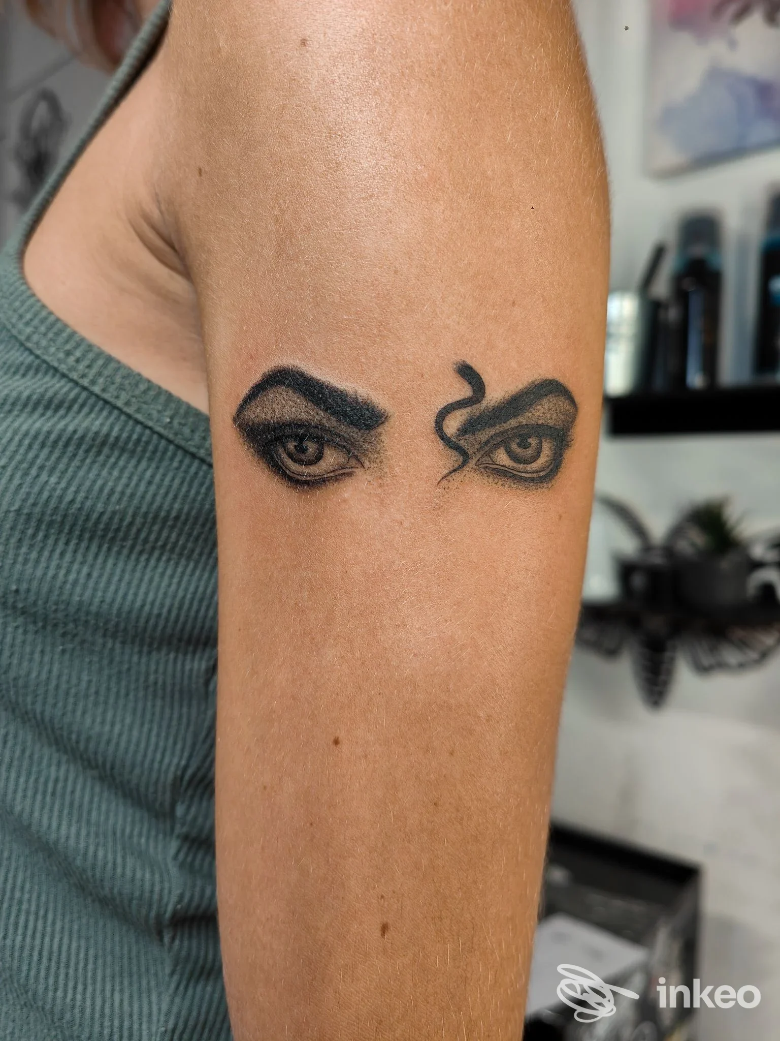 Tatuaggio di due occhi neri sul bicipite, foto realizzata da Skin Mood Tattoo a Spoleto.