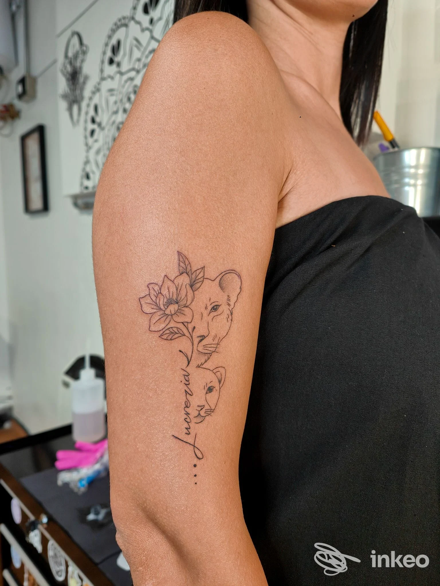 Tatuaggio a linee sottili con fiore e profilo sul braccio superiore, foto inviata da Skin Mood Tattoo a Spoleto.