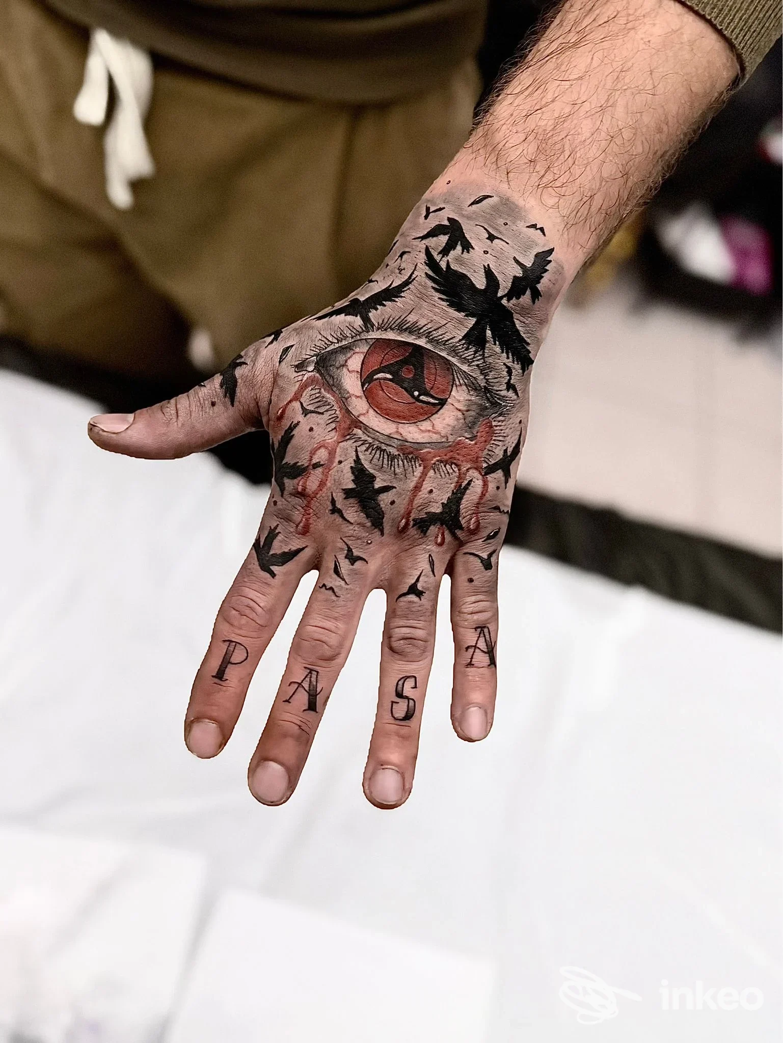 Mano tatuata con grande occhio stilizzato e elementi neri, foto dello studio Tatuaggi Terni Andrea Roseti Psycho Circus Tattoo a Terni.