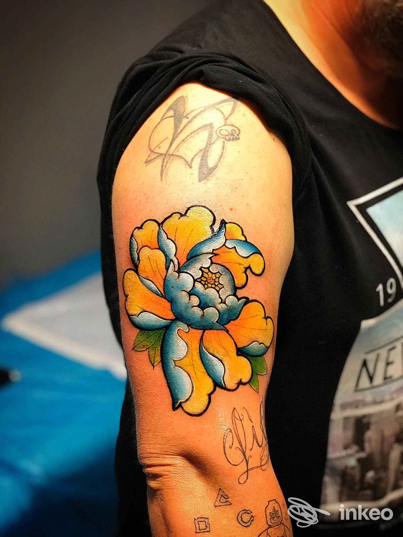 Tatuaggio floreale a colori sul braccio superiore, foto inviata da Psycho Circus Tattoo, Terni.