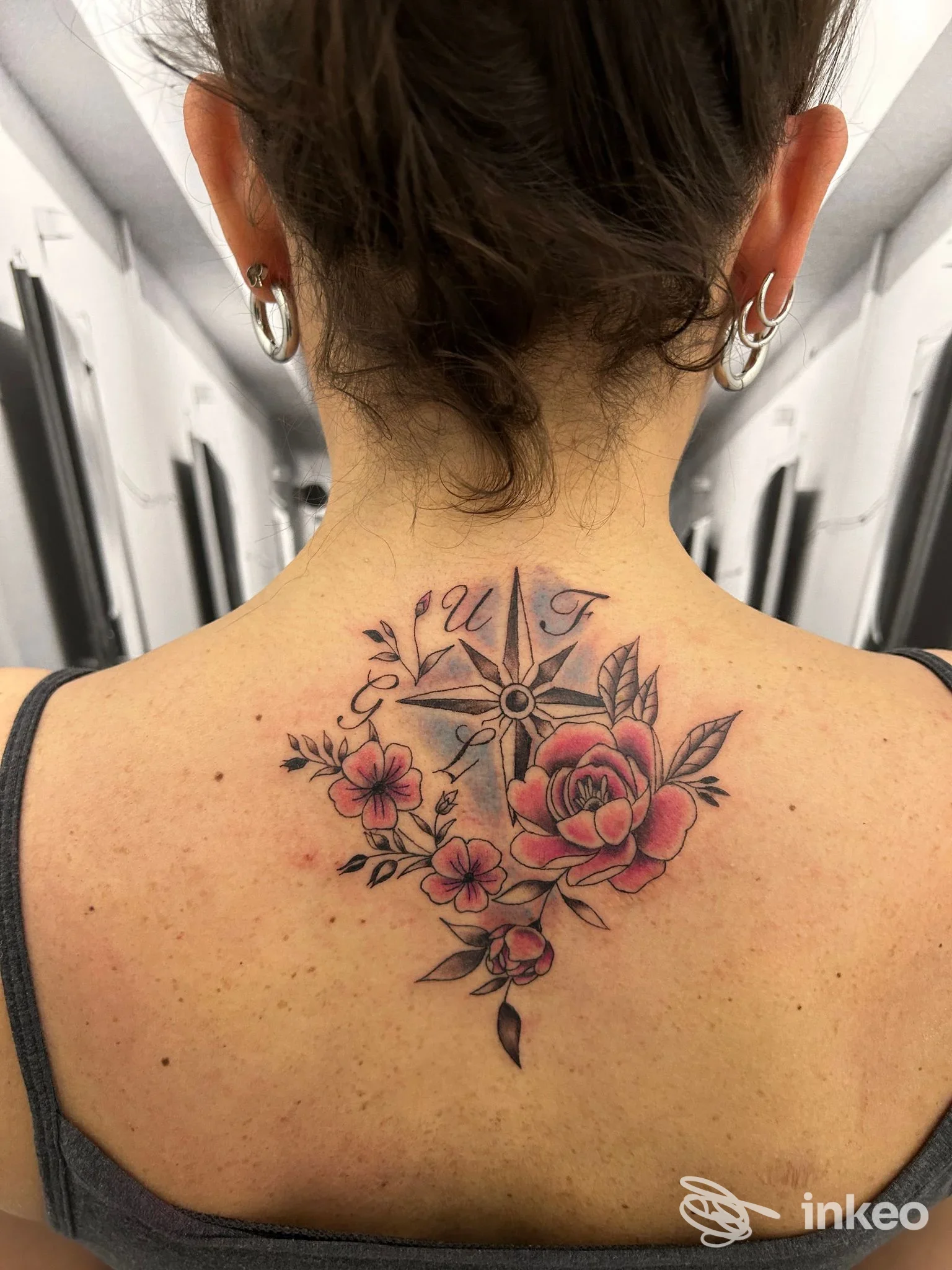 Tatuaggio al centro della nuca con rosa, fiori e rosa dei venti, realizzato da The Prison Tattoo a Gubbio.