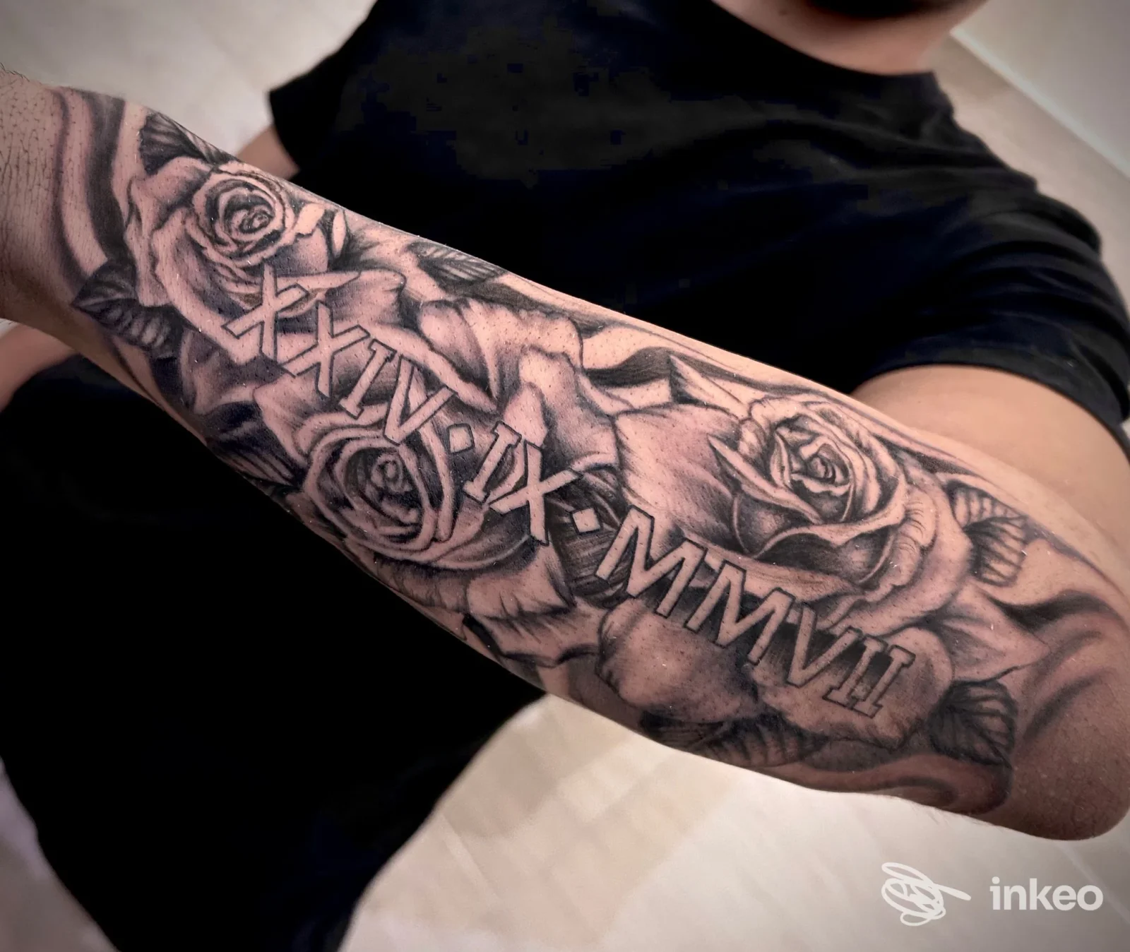 Avambraccio tatuato con rose e numeri romani, foto inviata da TATTOO SHOP JOE VALENTINO a Magione.