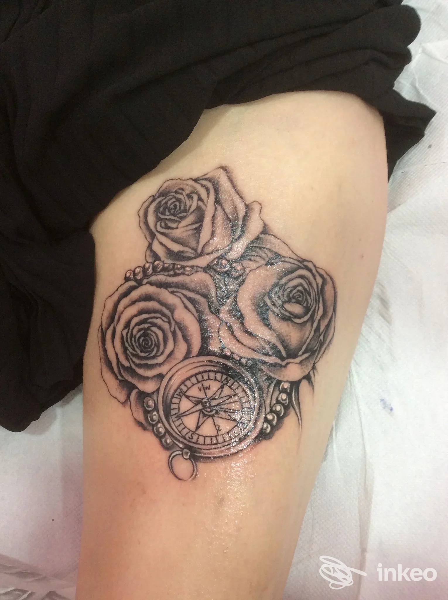 Tatuaggio black & grey con tre rose e bussola sulla coscia, eseguito da Tattooshka a San Giustino.