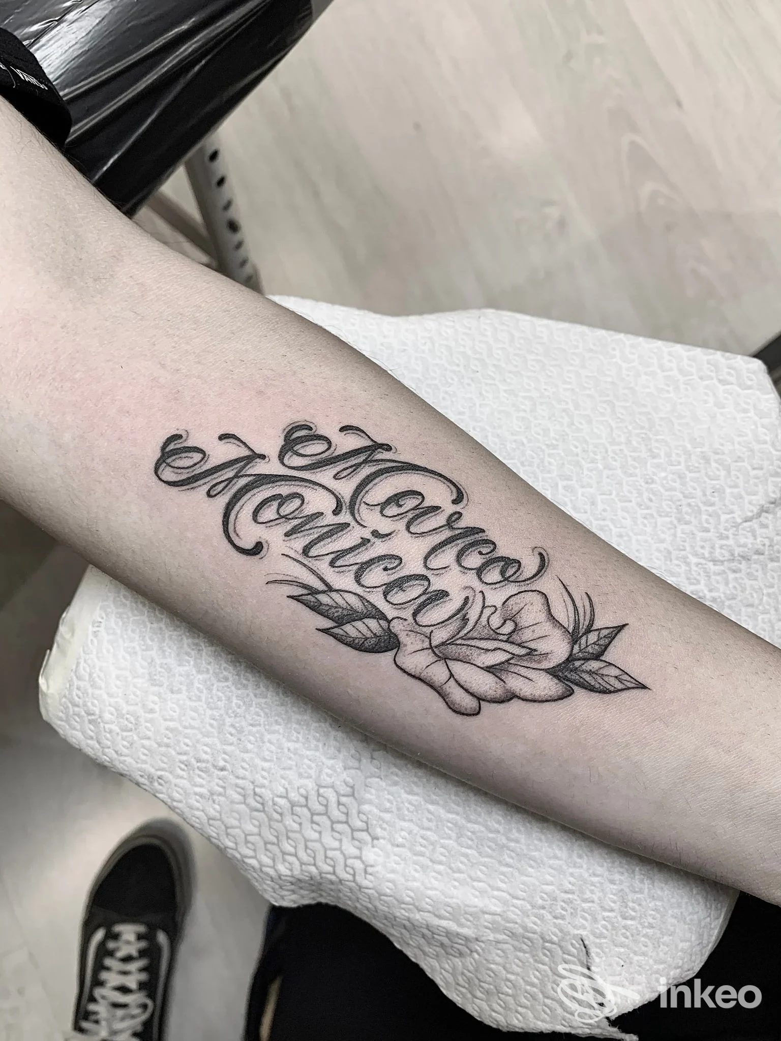 Tatuaggio lettering con fiore sull'avambraccio interno, fotografia di The Bridge Tattoo Club a Ponte San Giovanni.