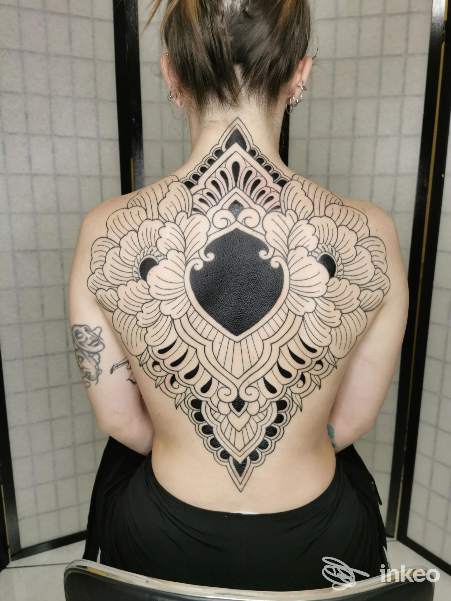 Ampio tatuaggio ornamentale in nero sulla schiena di una persona, realizzato presso XTC PIERCING TATTOO STUDIO, Perugia.