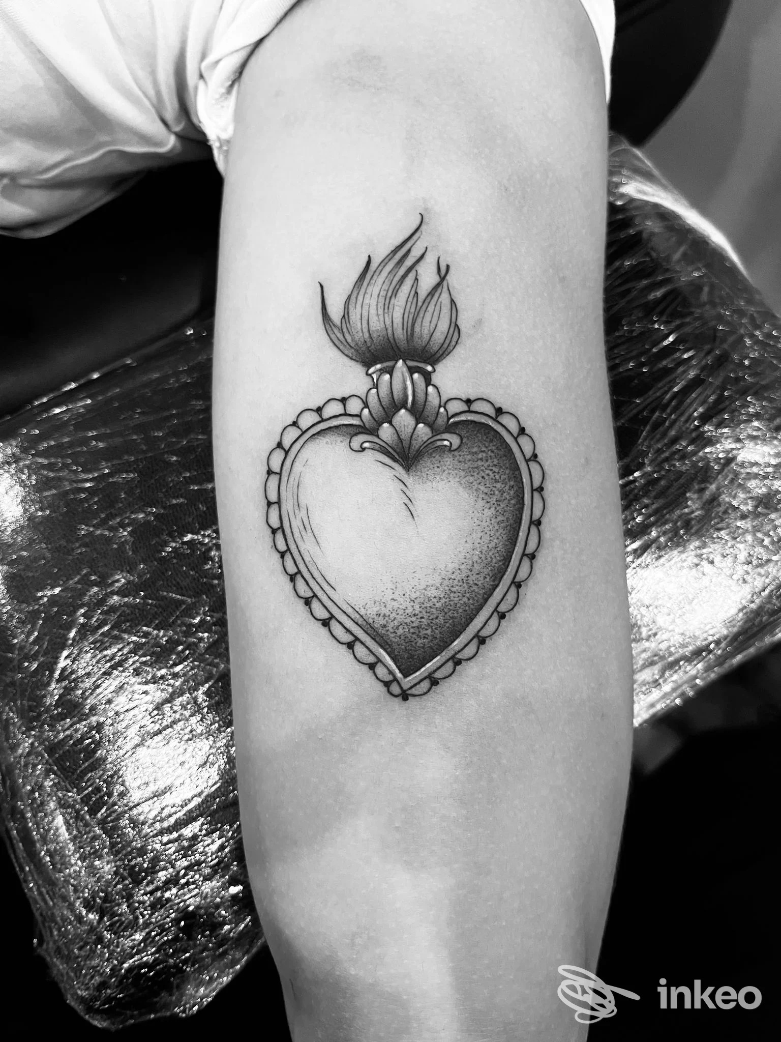 Tatuaggio a cuore fiammeggiante in blackwork e dotwork sull'avambraccio, realizzato da TOMMY blacktattoo ad Aosta.