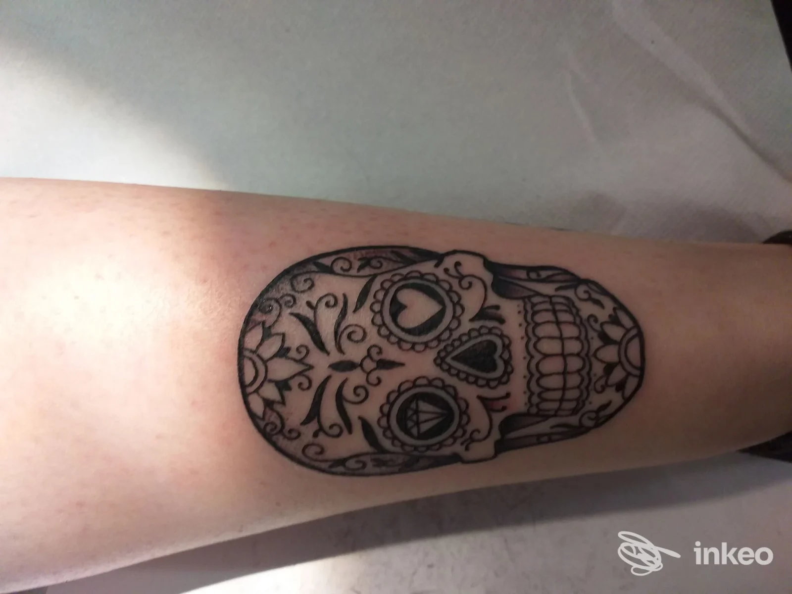 Tatuaggio sugar skull in bianco e nero sull'avambraccio, realizzato da Tattoo You ad Aosta.