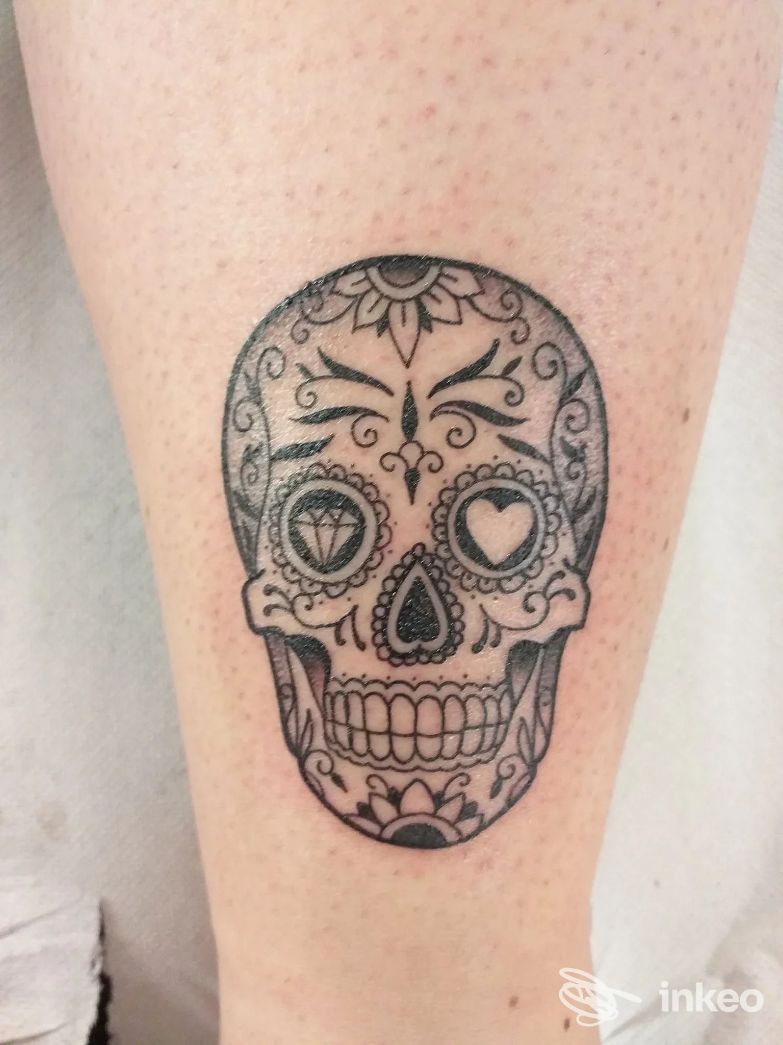 Tatuaggio teschio in stile sugar skull in nero sul polpaccio; foto fornita dallo studio Tattoo You, Aosta.