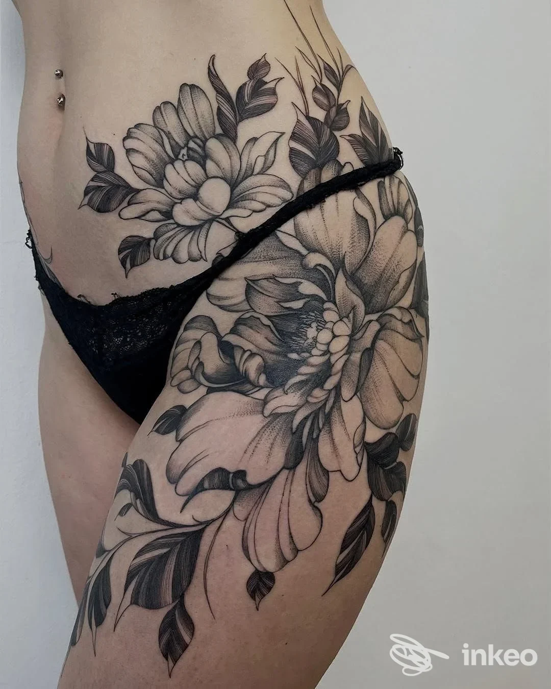 Grande tatuaggio floreale in bianco e nero sul fianco e coscia, foto fornita da 37049 TattooStudio, Villa Bartolomea.