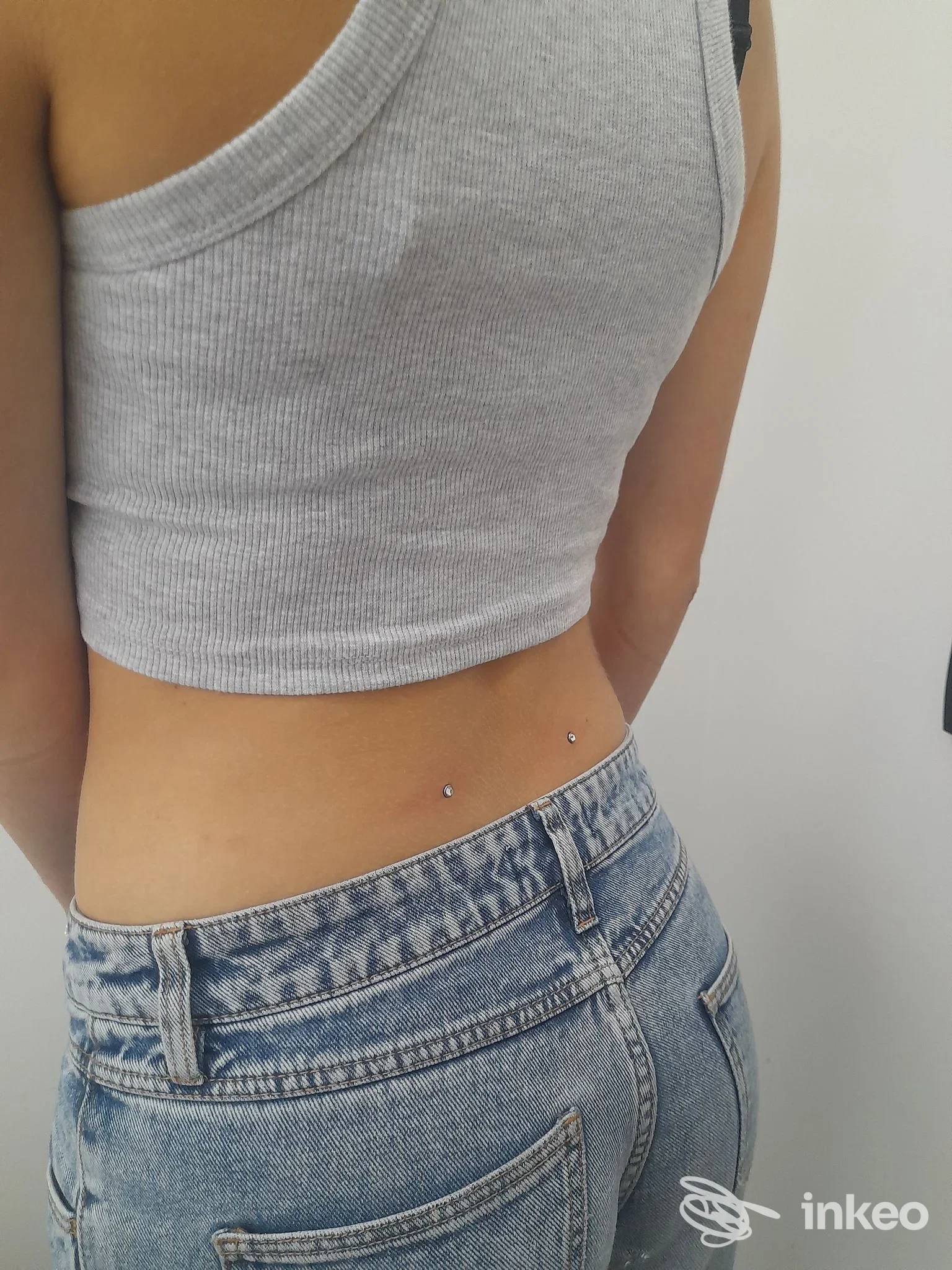 Due microdermal posizionati sulla parte bassa della schiena, fotografia per Aisha Tattoo & piercing, Thiene.