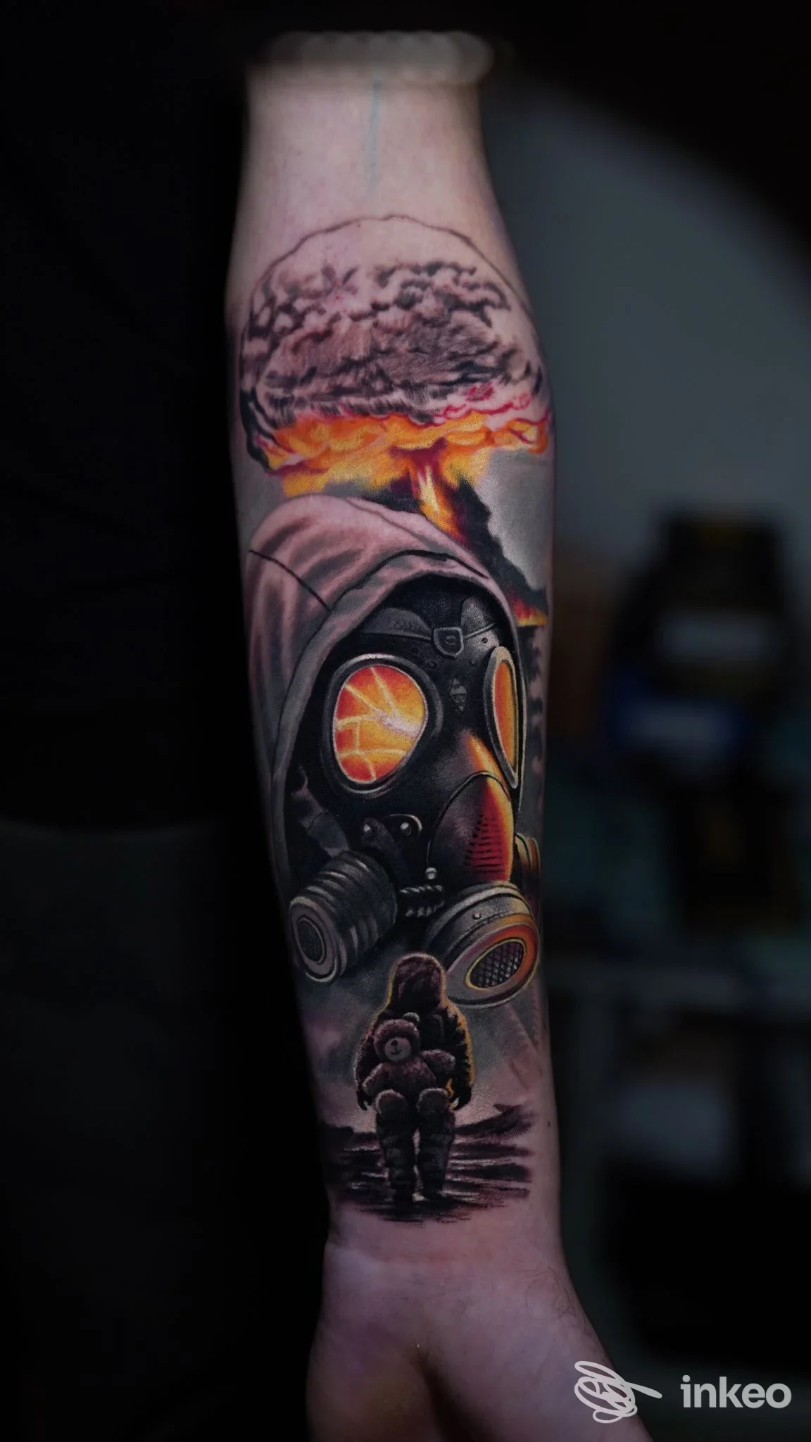 Tatuaggio realistico su avambraccio con maschera antigas, riflessi arancioni e nube a fungo — Ale Art Tattoo, Montecchio Maggiore.