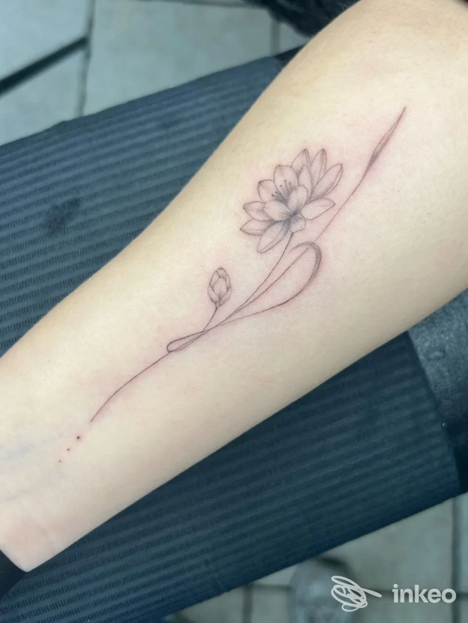 Delicato tatuaggio minimal di fiore sul avambraccio, linea sottile e ombreggiatura soffusa — foto per Ante Signum Tattoo Studio, San Giovanni Lupatoto.