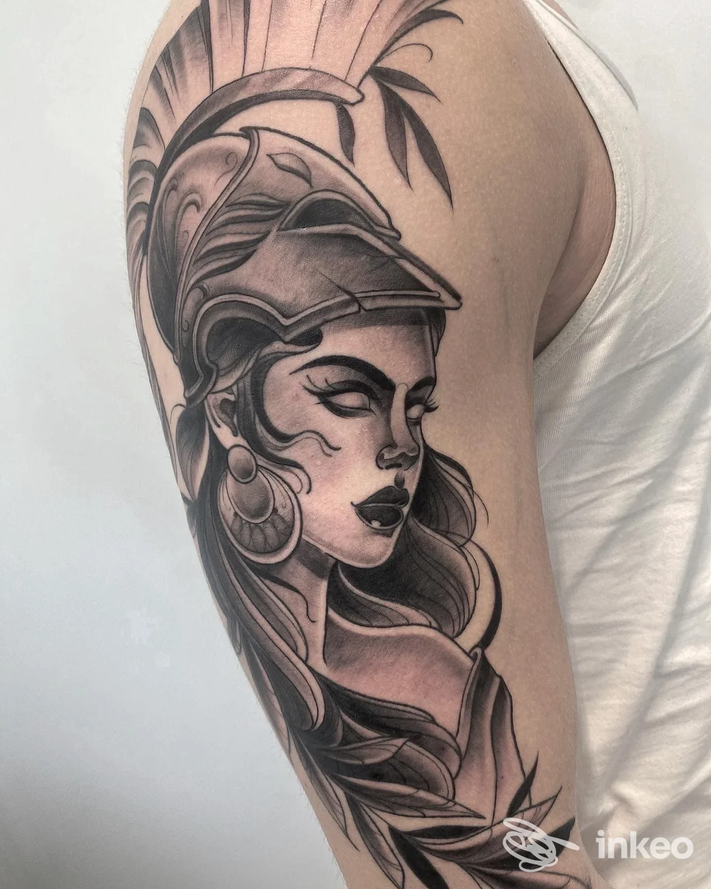Tatuaggio su braccio superiore che ritrae una figura femminile con elmo, Arcana Tattoo Studio, Venezia.