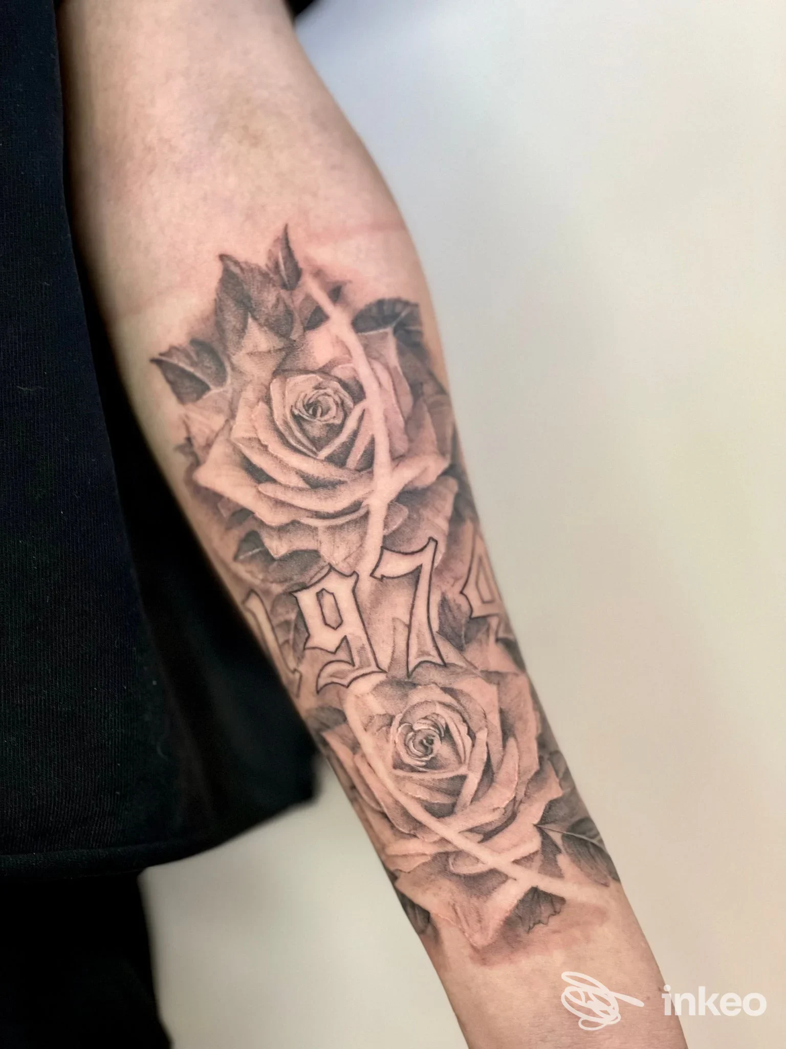 Tatuaggio realistico di rose e numeri sull'avambraccio. Foto per Arte Incisa Tattoo, Chirignago-Zelarino.